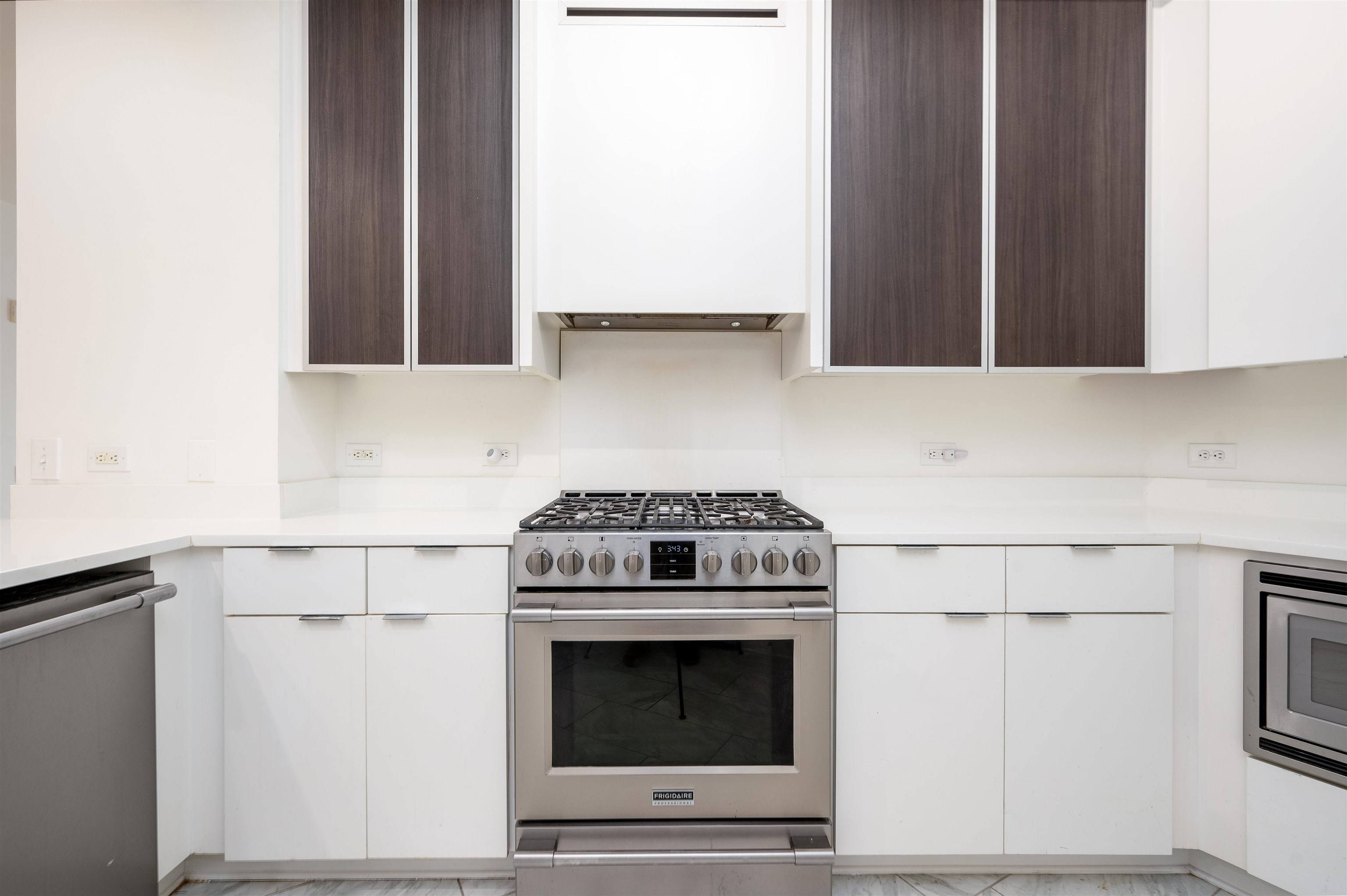 Kitchen featuring stainless steel appliances and white cabinetry