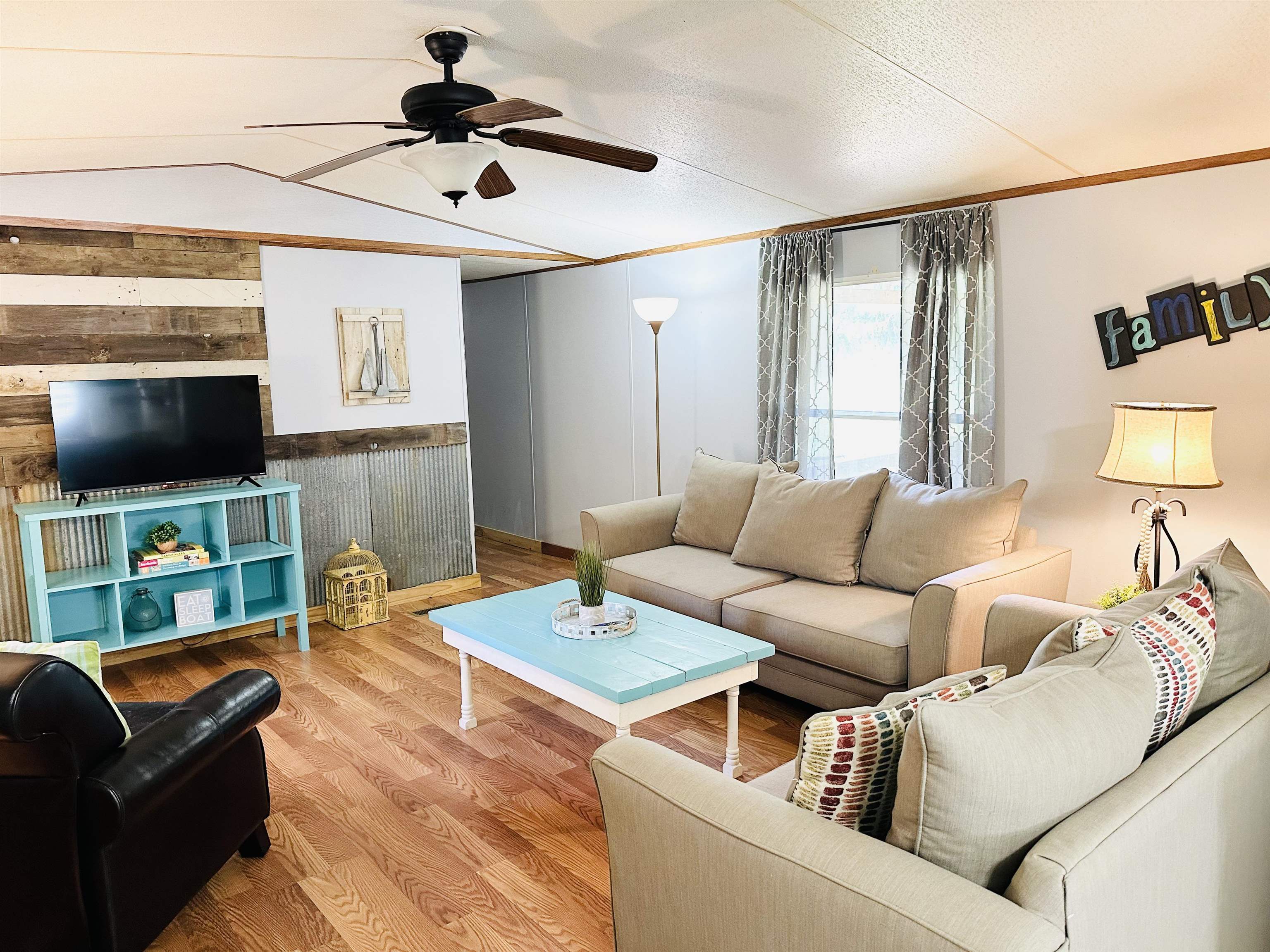 Living room with wood-type flooring, ceiling fan, and chair railing