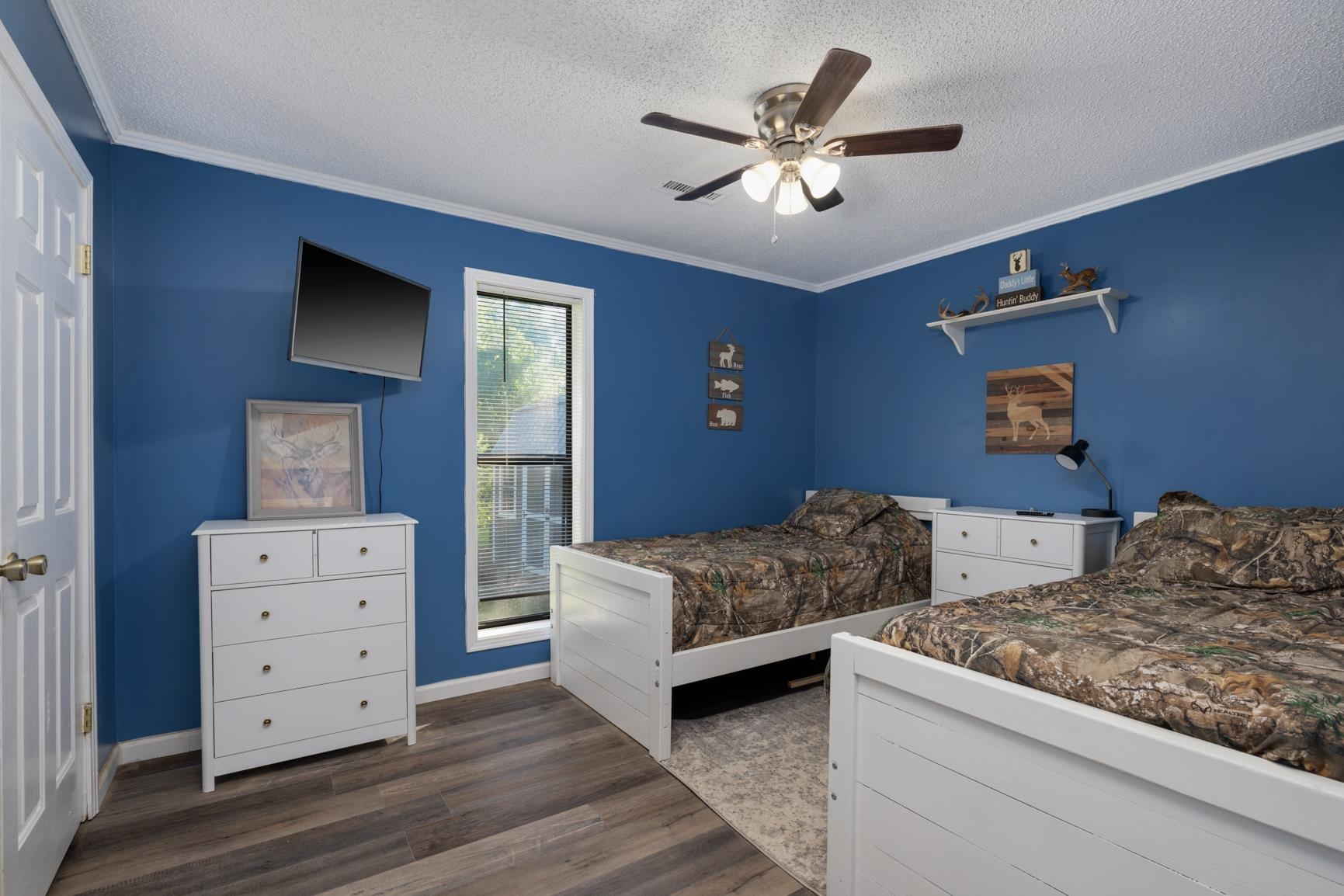 Bedroom with ceiling fan, ornamental molding, a textured ceiling, and dark hardwood / wood-style flooring