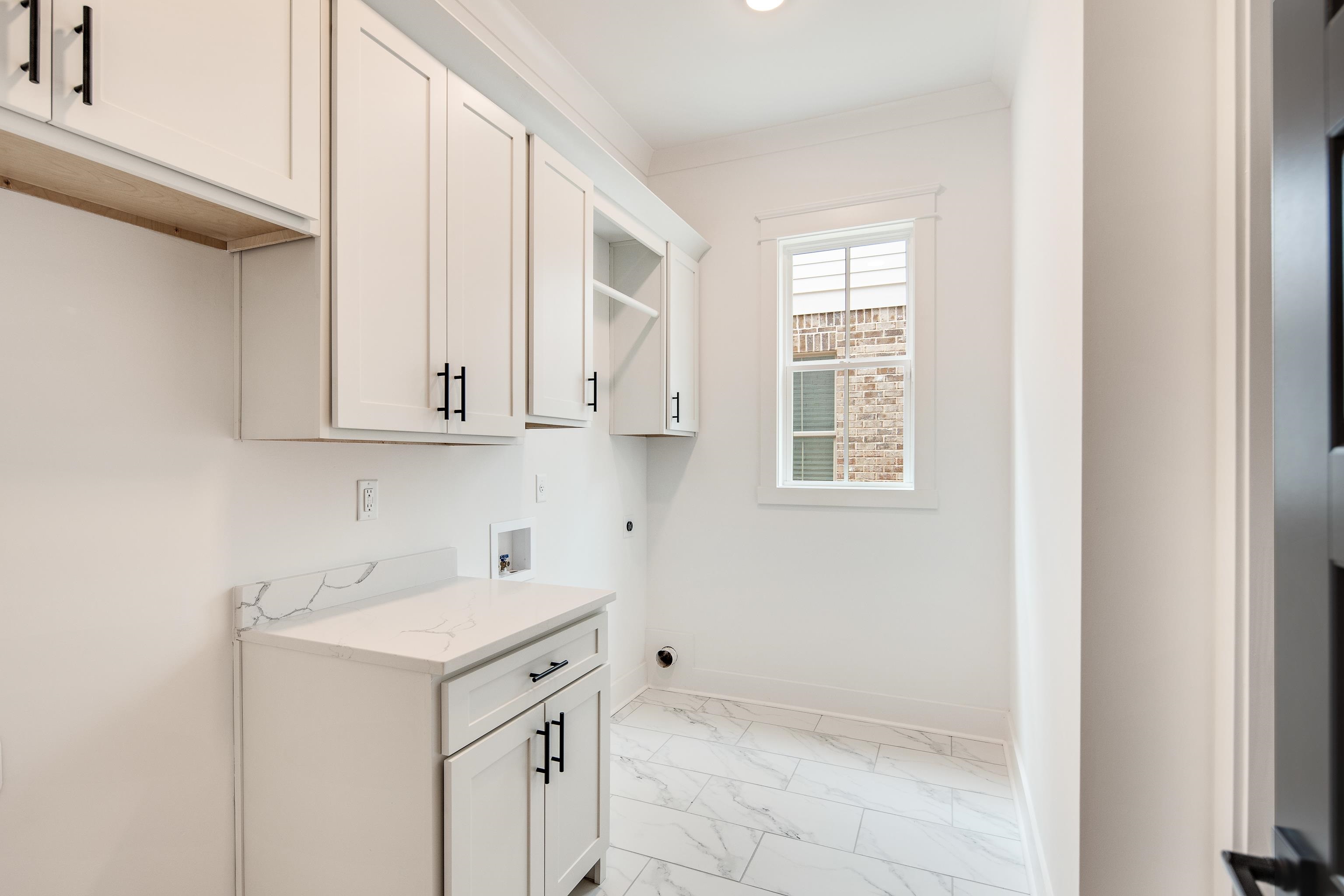 Washroom with cabinets, hookup for an electric dryer, washer hookup, and crown molding