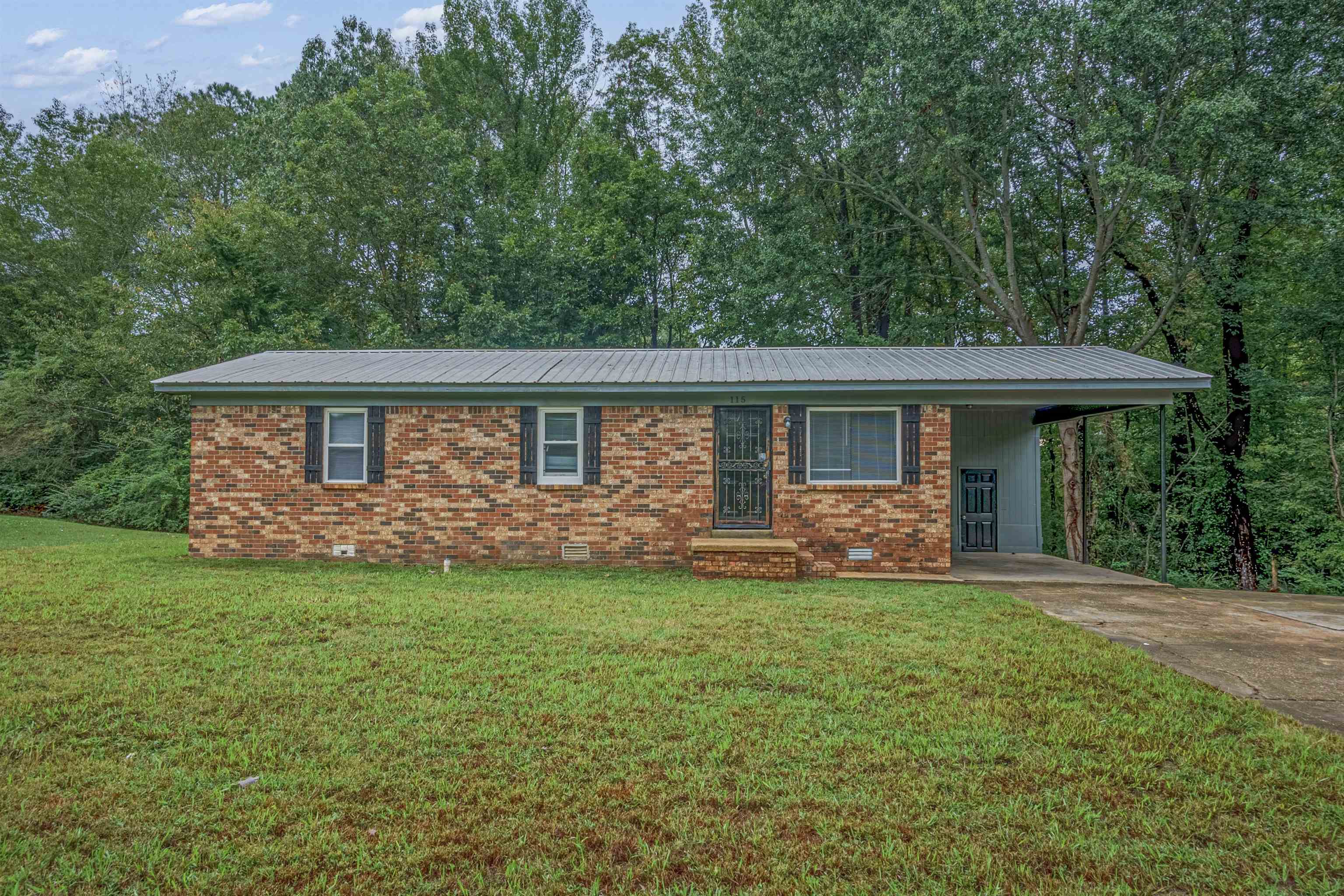 Single story home featuring a carport and a front yard