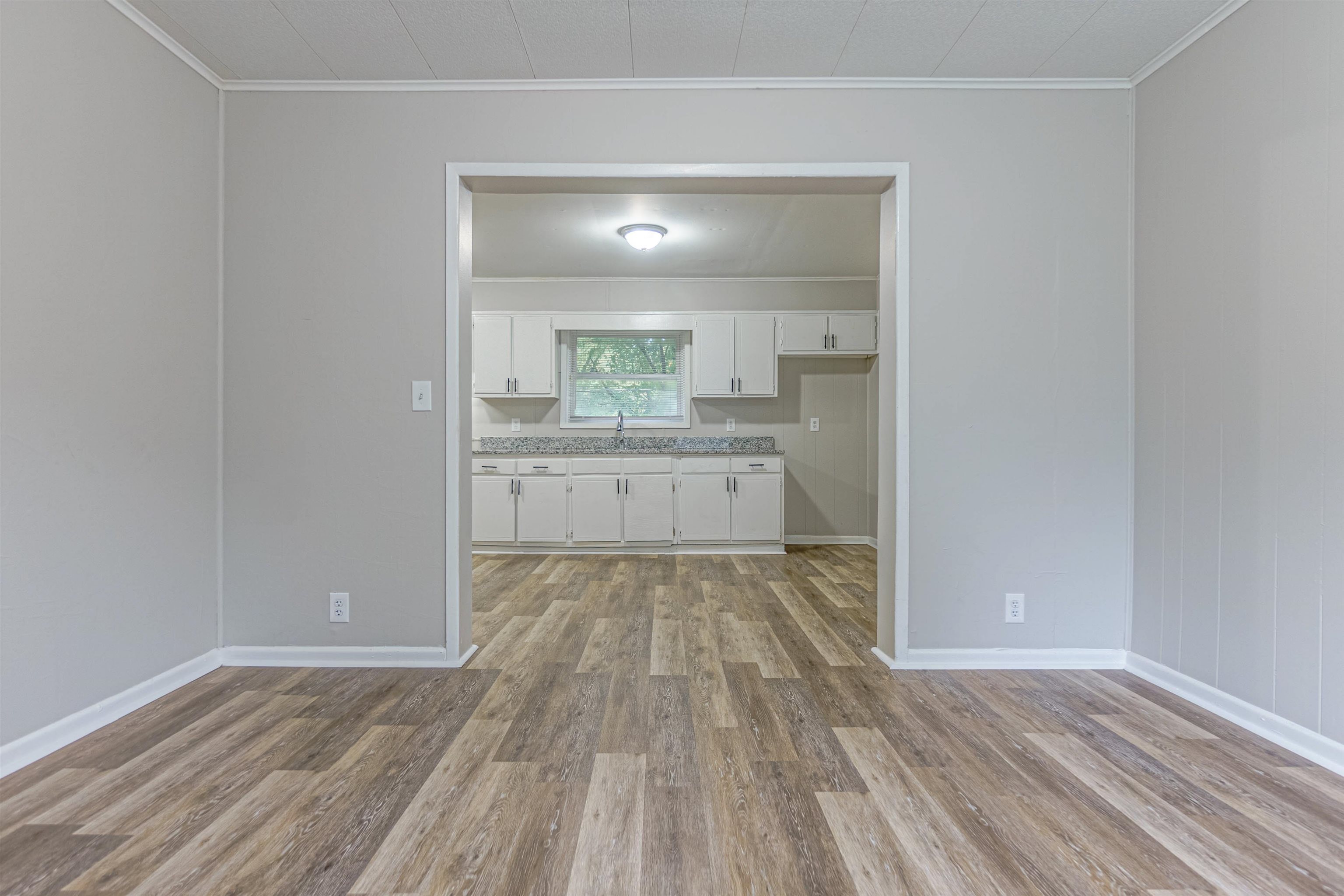 Interior space featuring ornamental molding, sink, and light hardwood / wood-style flooring