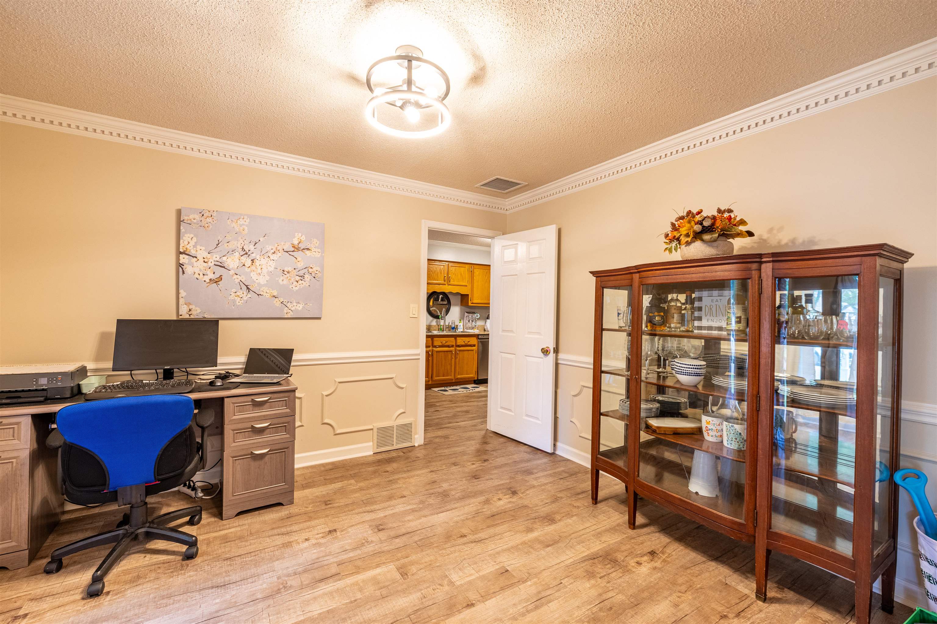 Office with a textured ceiling, light hardwood / wood-style floors, ornamental molding, and a chandelier