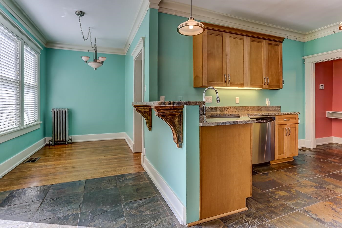 Kitchen featuring radiator, dishwasher, pendant lighting, and sink