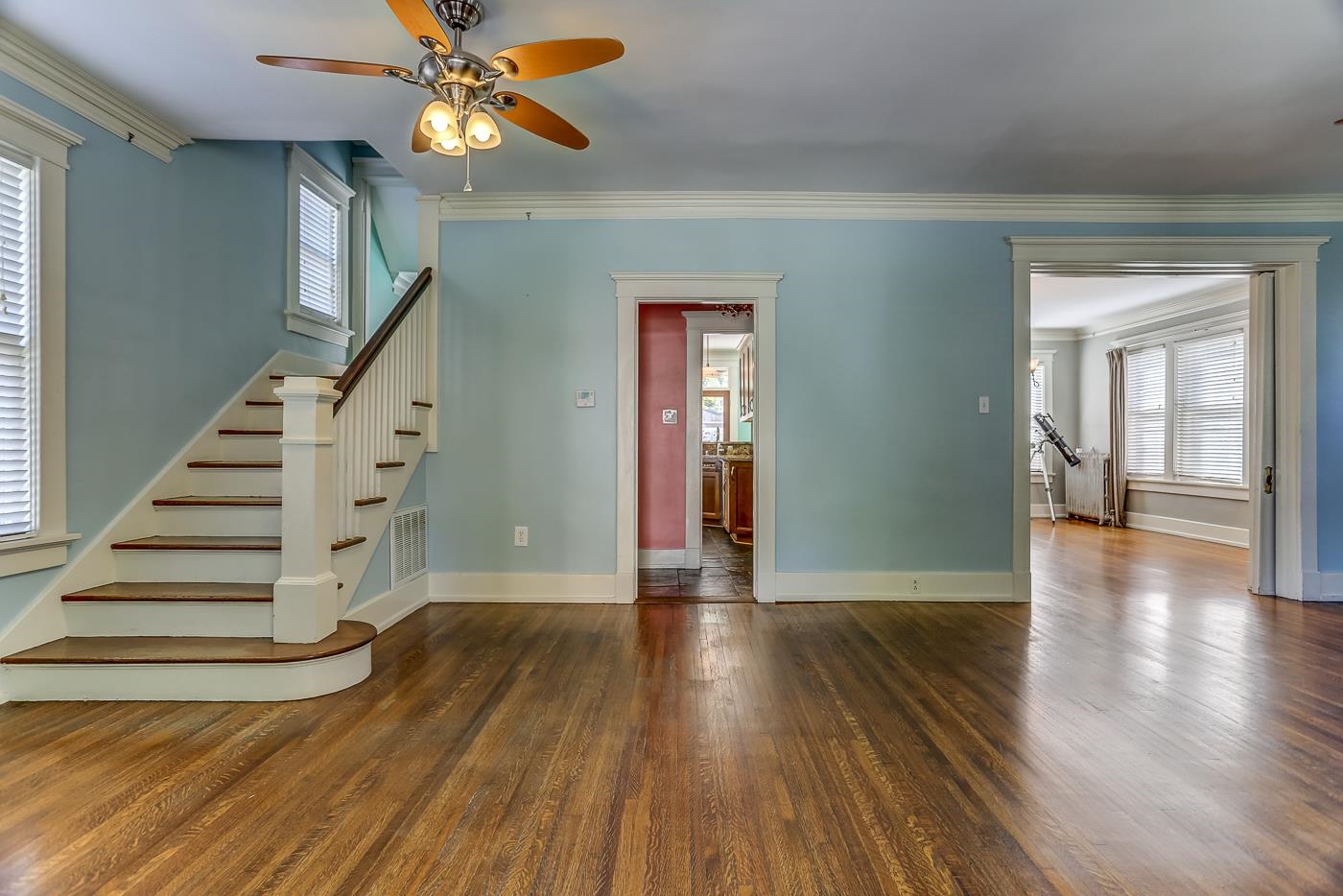 Unfurnished living room with a healthy amount of sunlight, ornamental molding, dark hardwood / wood-style floors, and ceiling fan