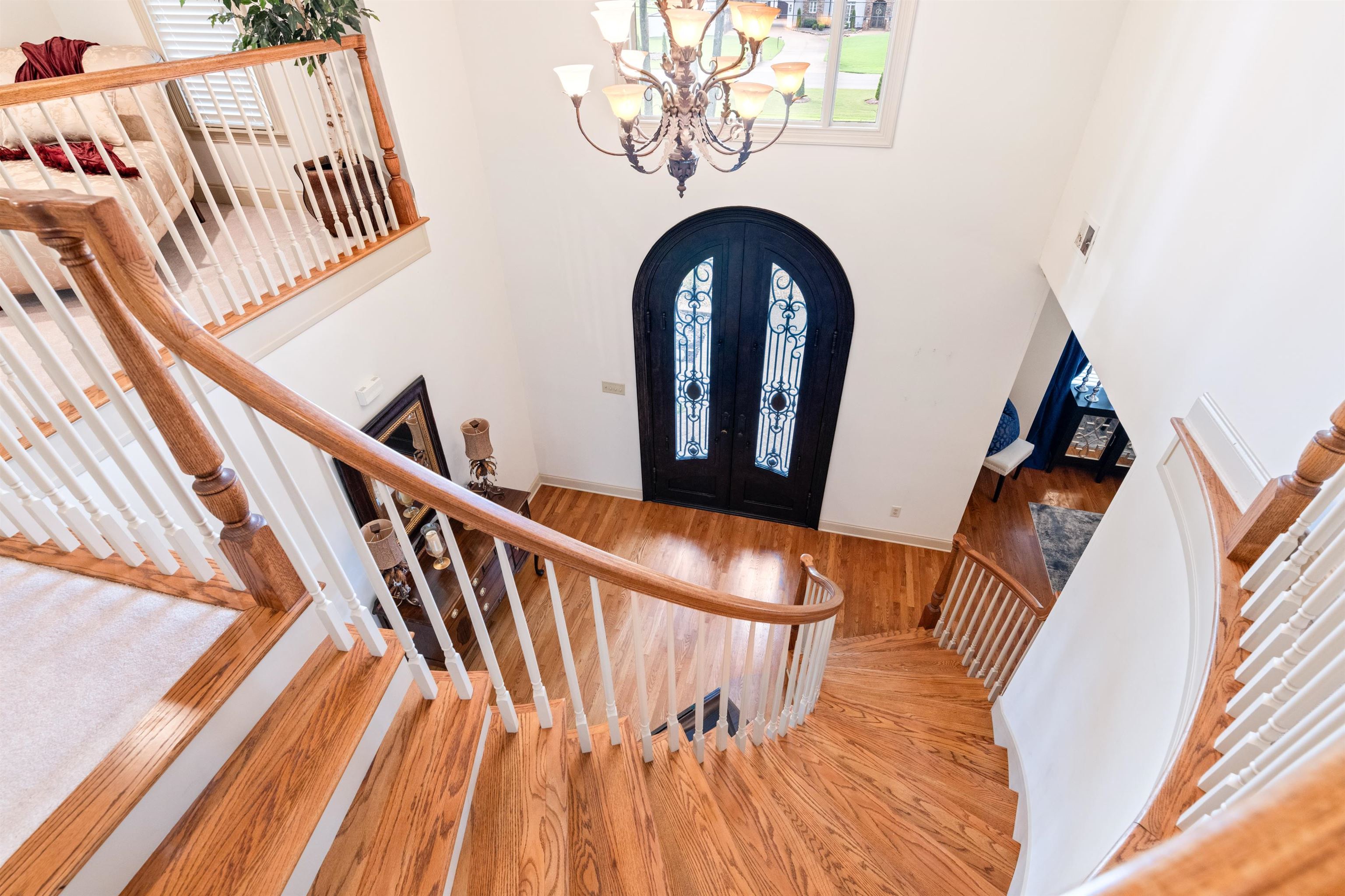 Foyer entrance featuring wood-type flooring, french doors, and a notable chandelier