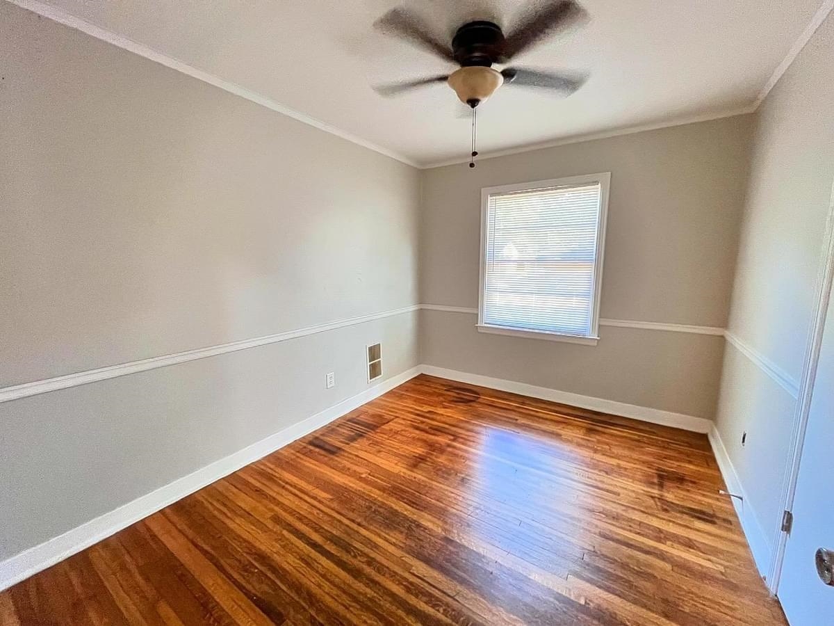 Spare room with ceiling fan, hardwood / wood-style flooring, and crown molding