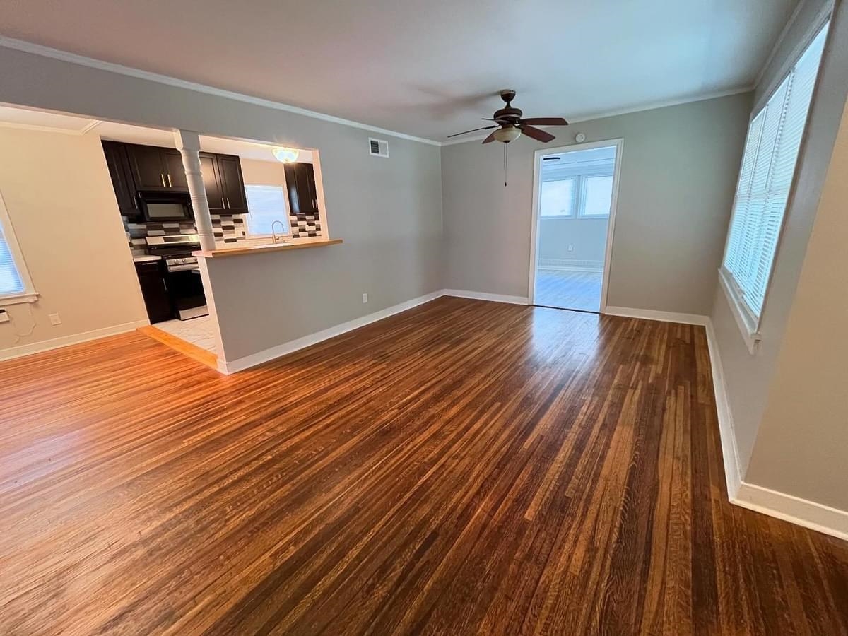 Empty room featuring ornamental molding, ceiling fan, dark hardwood / wood-style floors, and sink