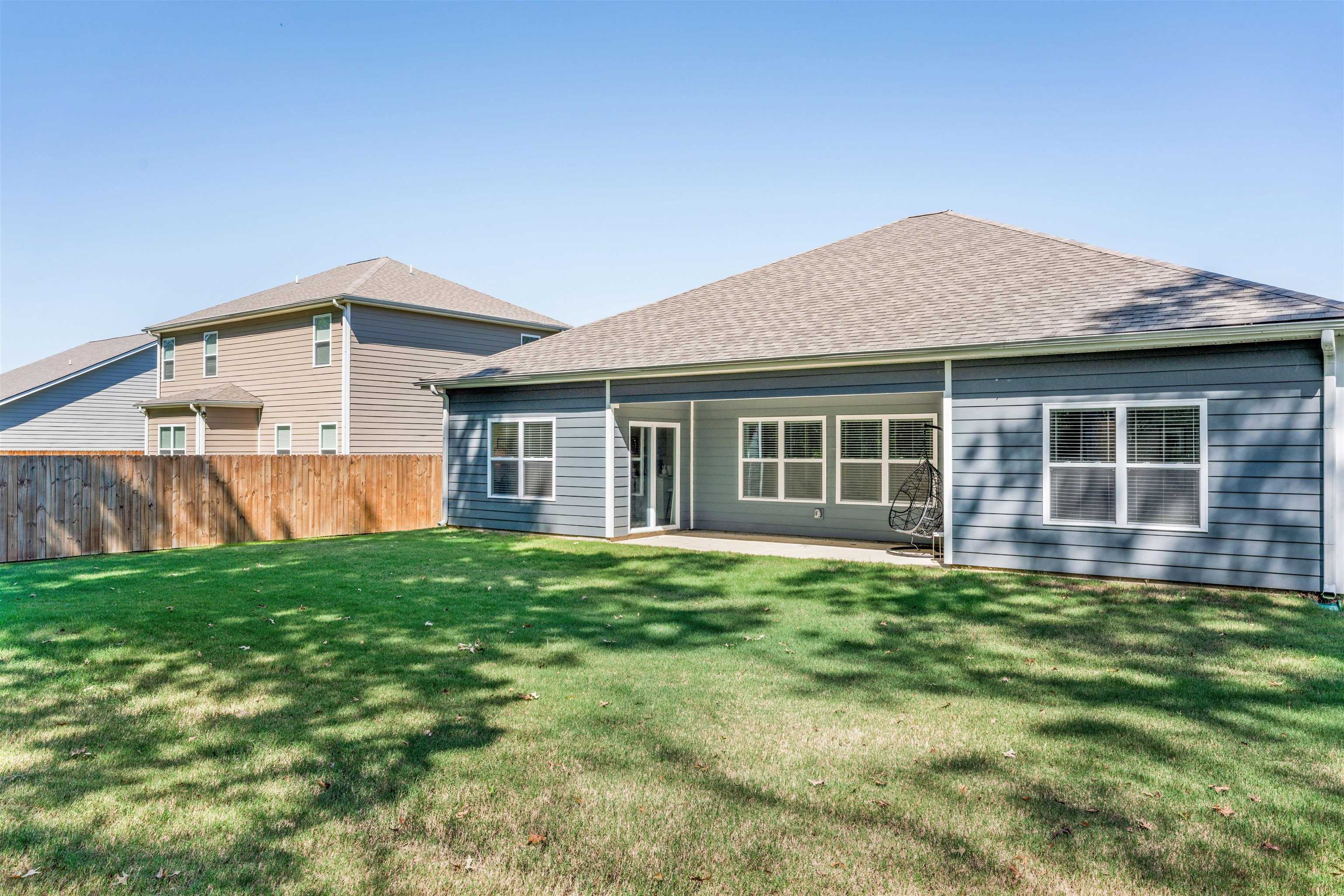 Rear view of house with a patio and a yard