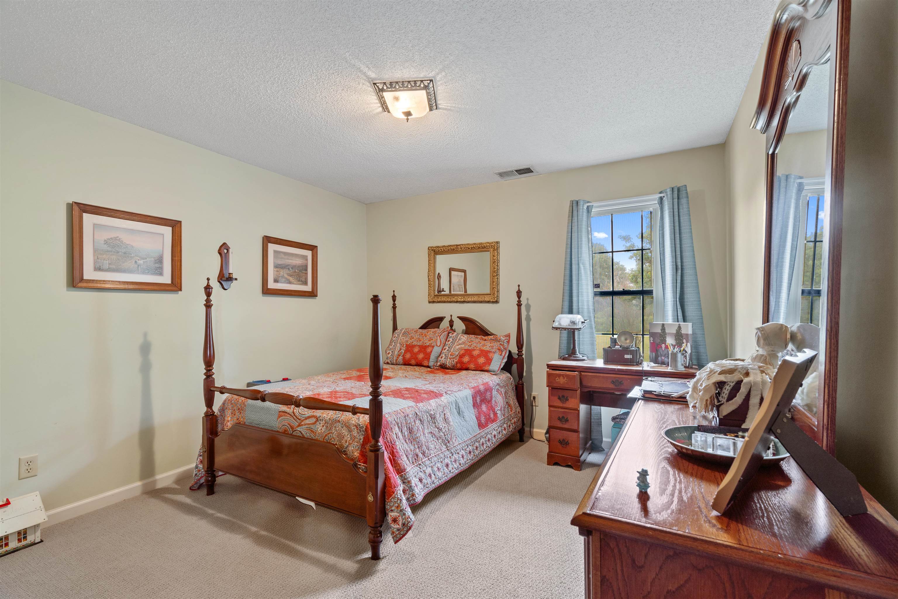 Bedroom featuring a textured ceiling and light colored carpet