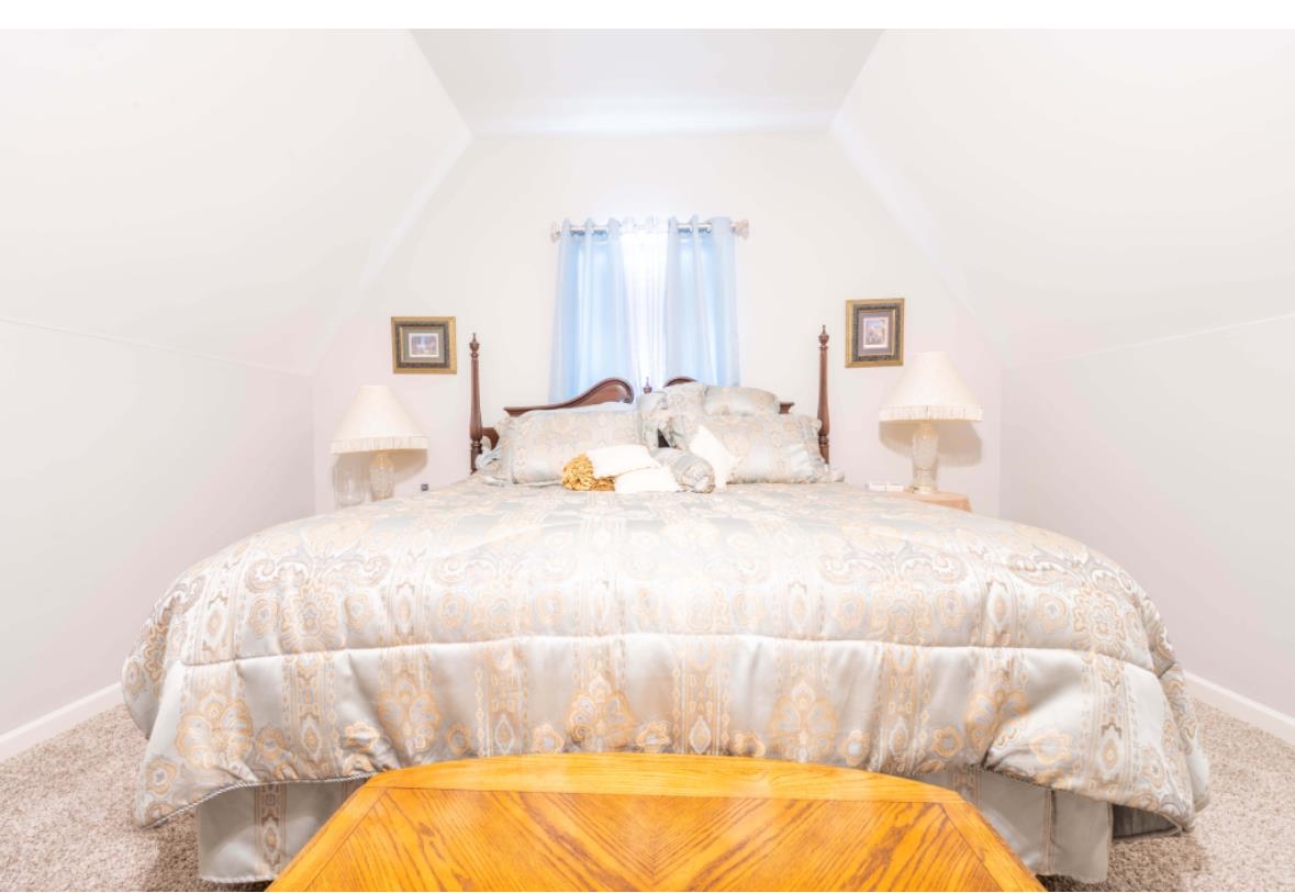 Carpeted bedroom with lofted ceiling