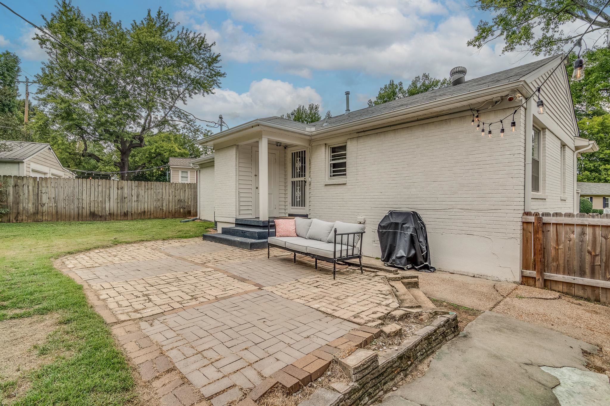 Back of property with a patio, a yard, and an outdoor living space