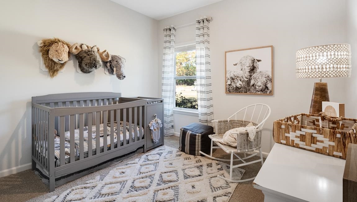 Bedroom featuring an inviting chandelier, a nursery area, and carpet flooring