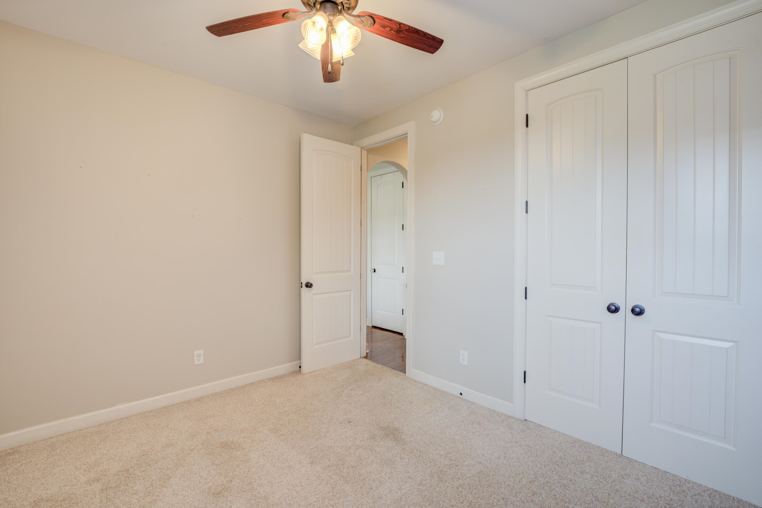 Unfurnished bedroom with ceiling fan, carpet floors, and a closet