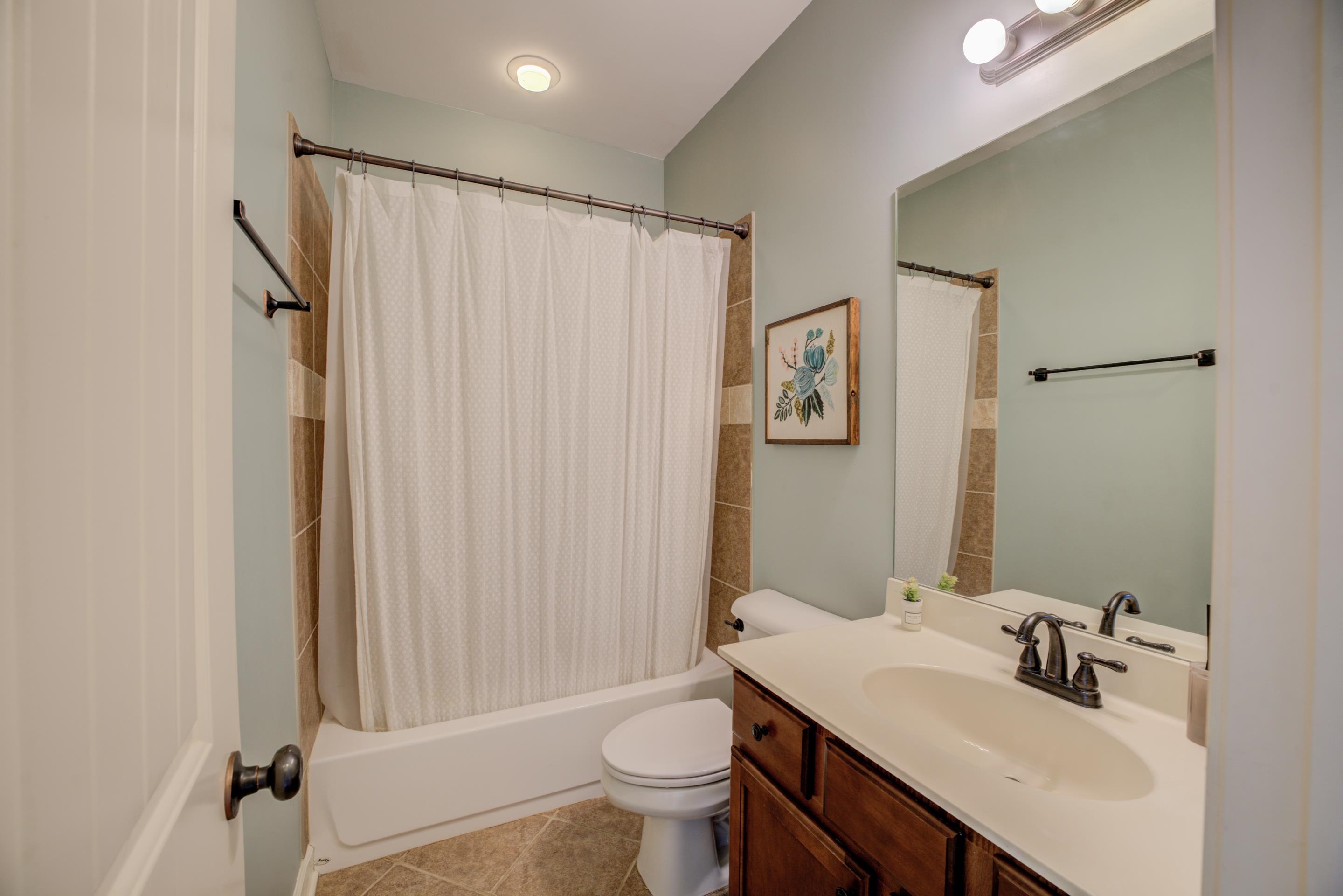 Full bathroom with vanity, tile patterned flooring, toilet, and shower / bathtub combination with curtain