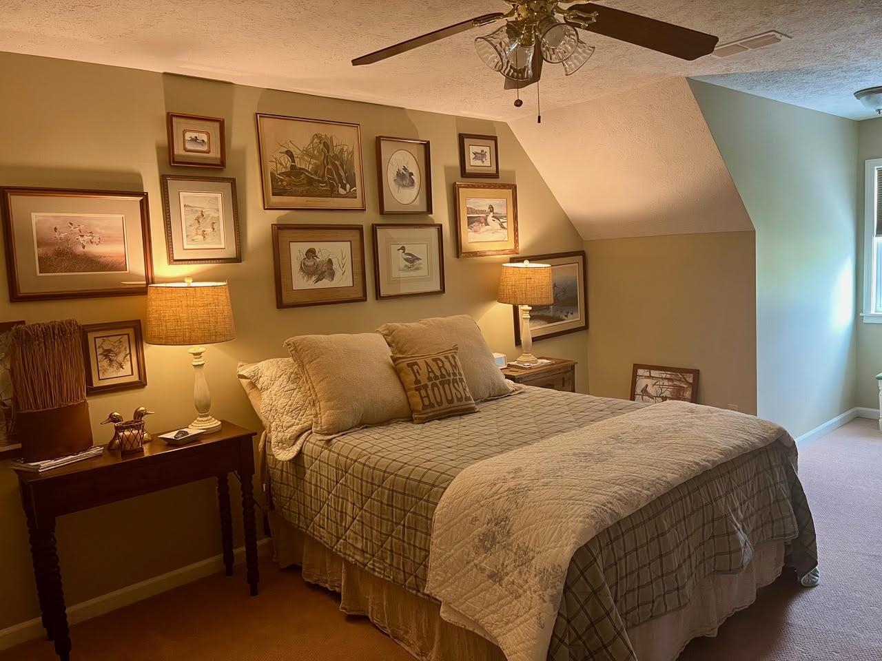 Bedroom featuring ceiling fan, a textured ceiling, lofted ceiling, and carpet