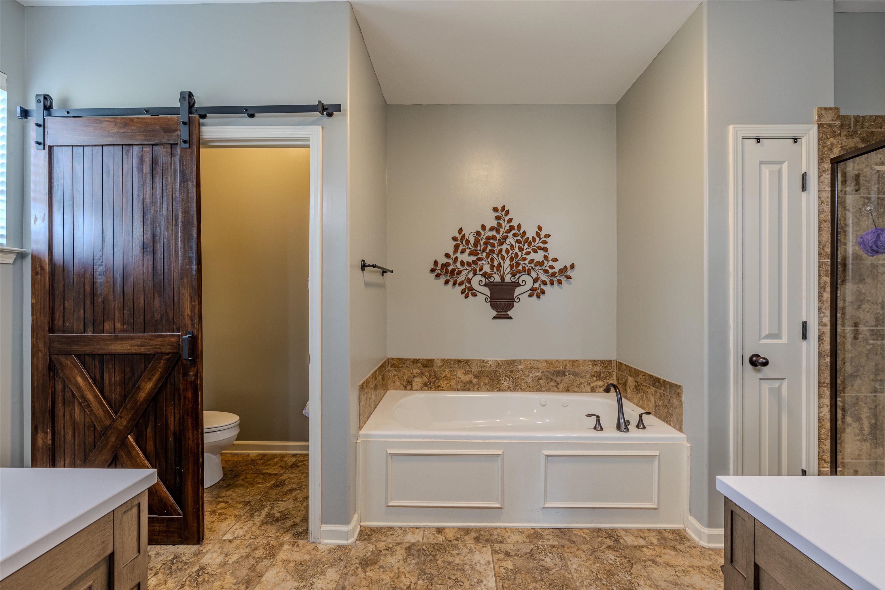 Bathroom featuring a whirlpool tub to relax in, double vanity, and private water closet/toilet room