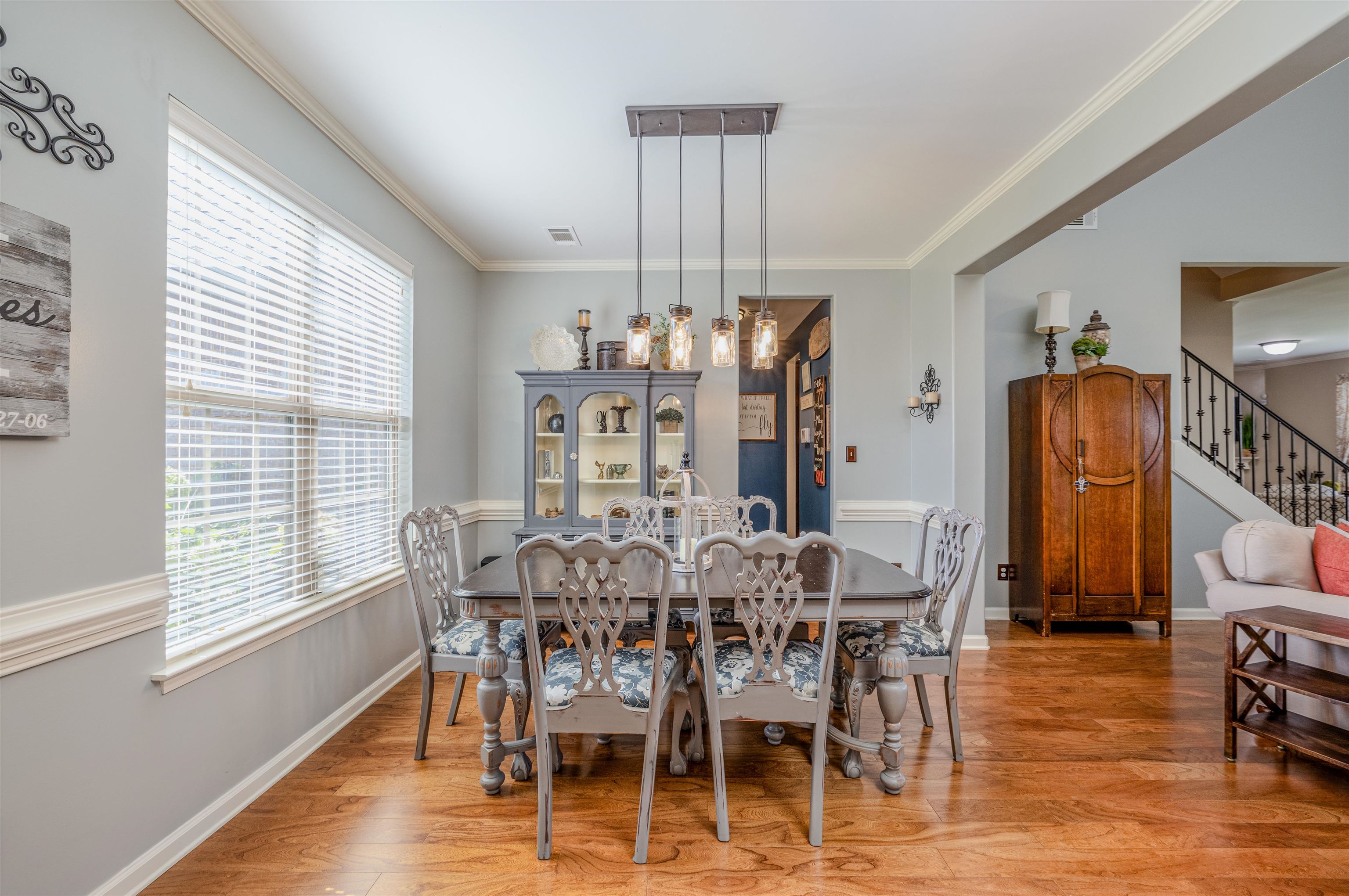 Dining area featuring ornamental molding, wood-type flooring, and an inviting chandelier