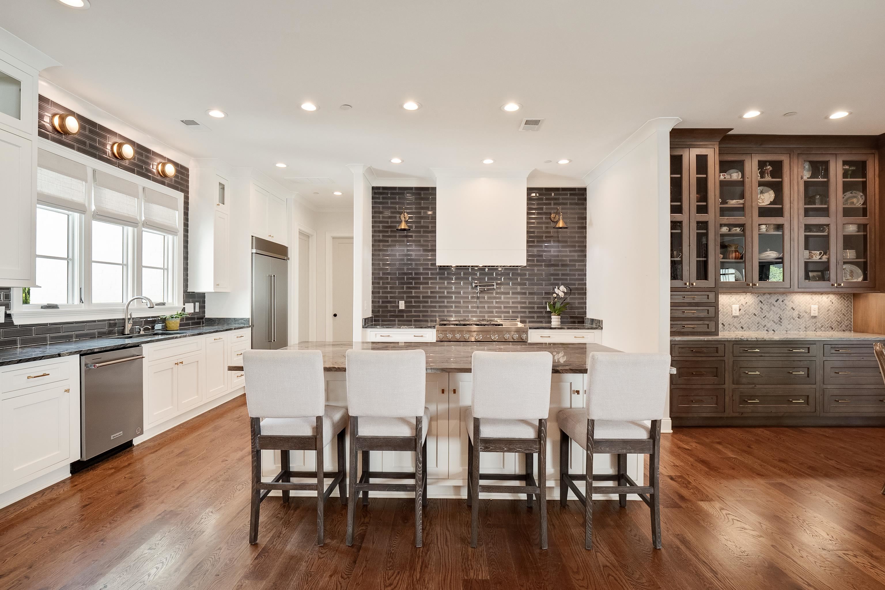 Kitchen featuring a center island, dark hardwood / wood-style floors, sink, white cabinetry, and stainless steel appliances