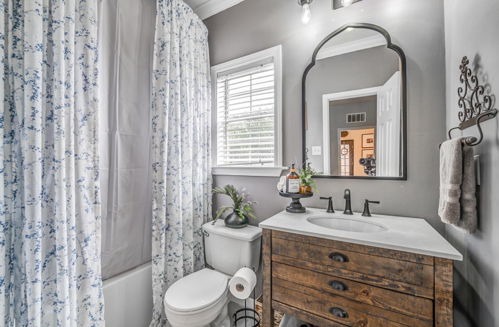 Full bathroom featuring vanity, crown molding, and toilet