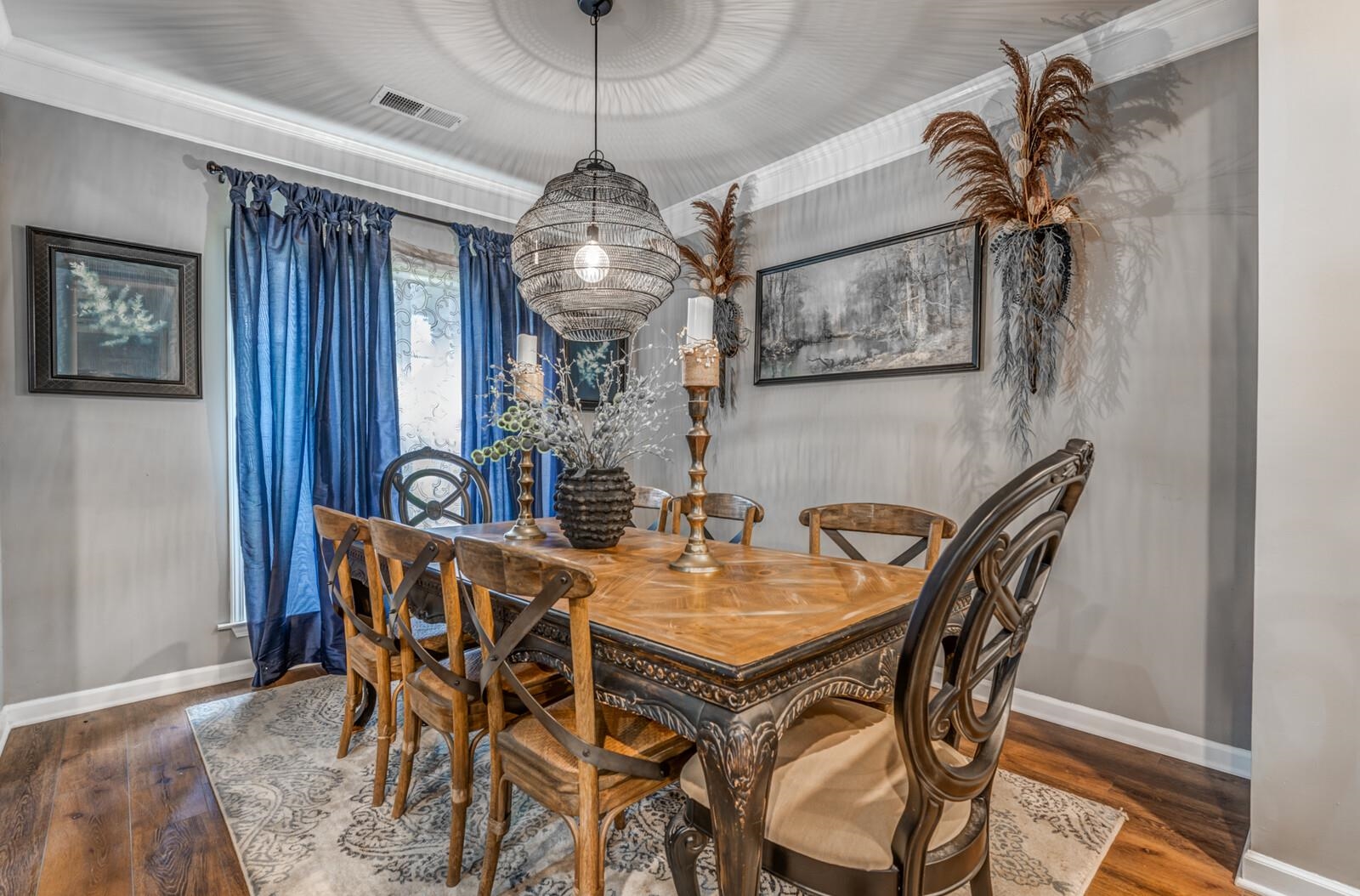 Dining room featuring a chandelier, dark hardwood / wood-style floors, and crown molding