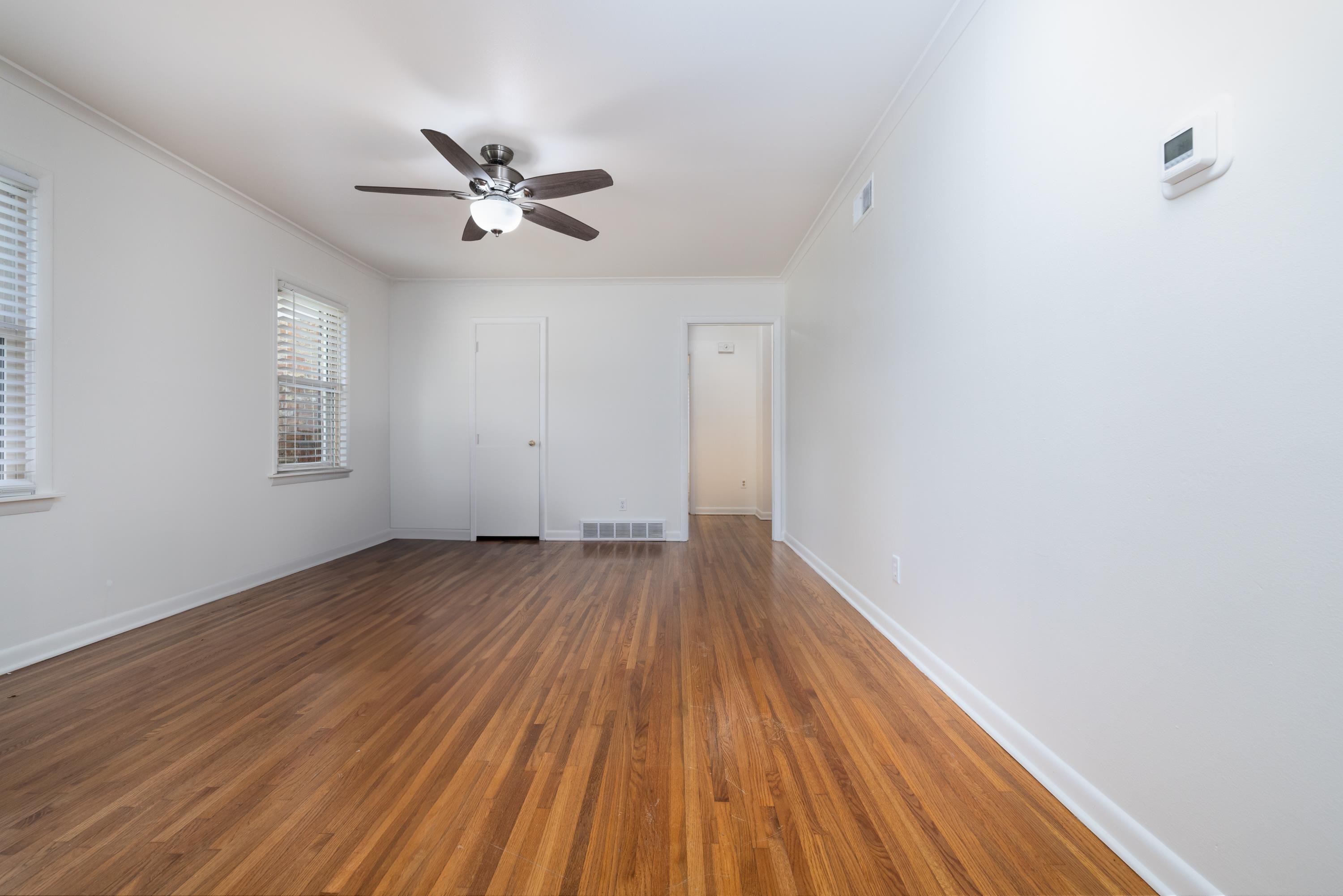 Spare room with ceiling fan, dark hardwood / wood-style floors, and crown molding