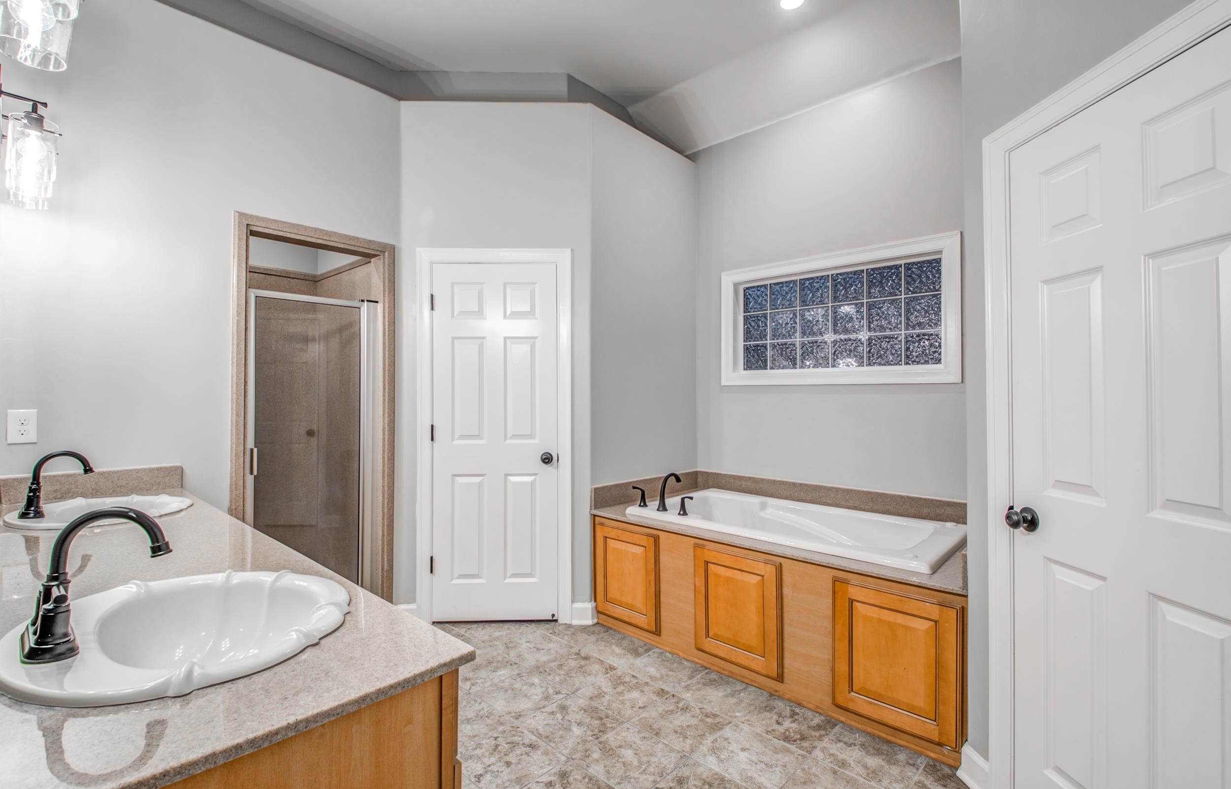 Bathroom featuring vanity, shower with separate bathtub, and tile patterned flooring