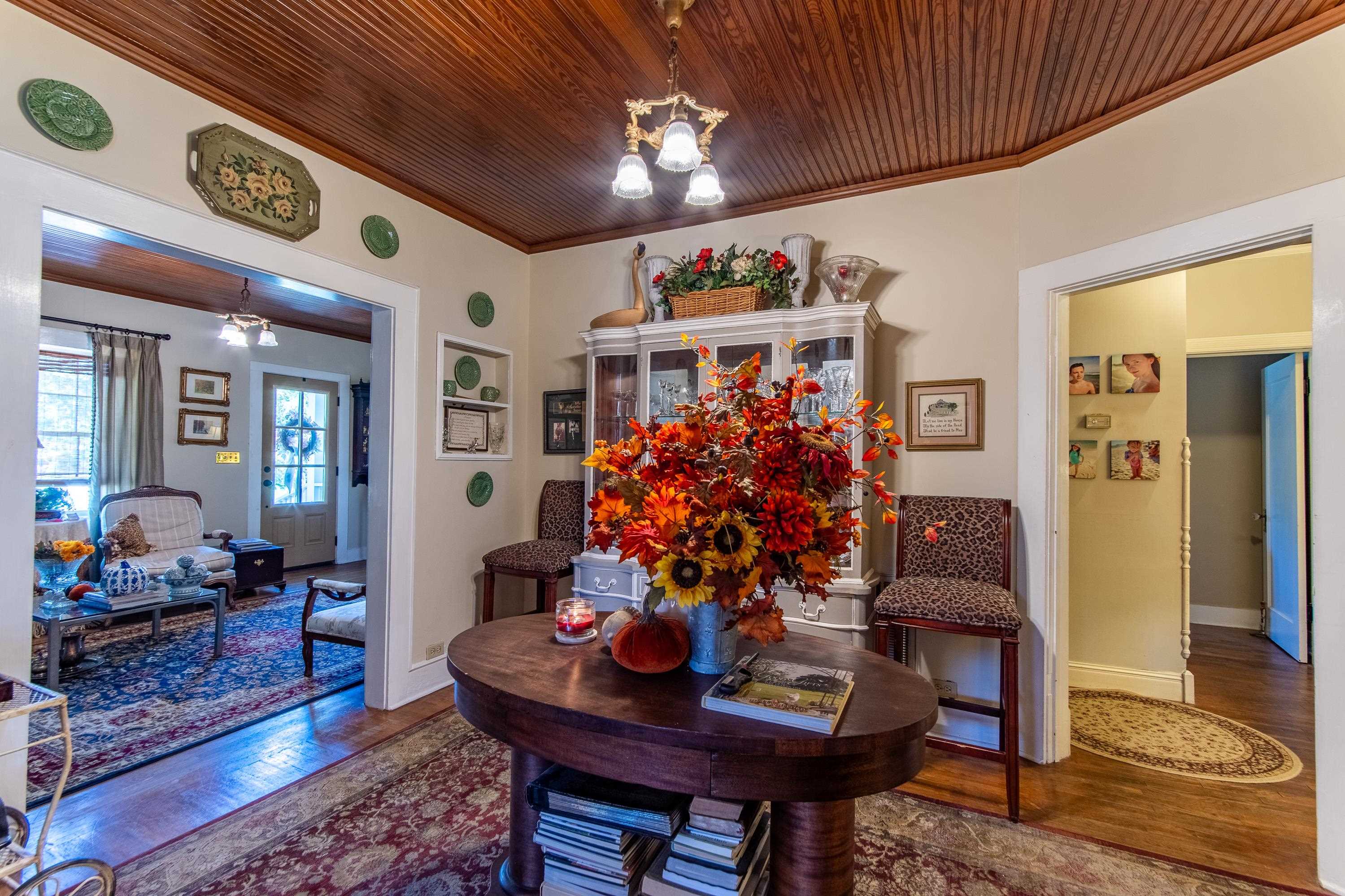 Dining room featuring ornamental molding, an inviting chandelier, dark hardwood / wood-style flooring, and wooden ceiling