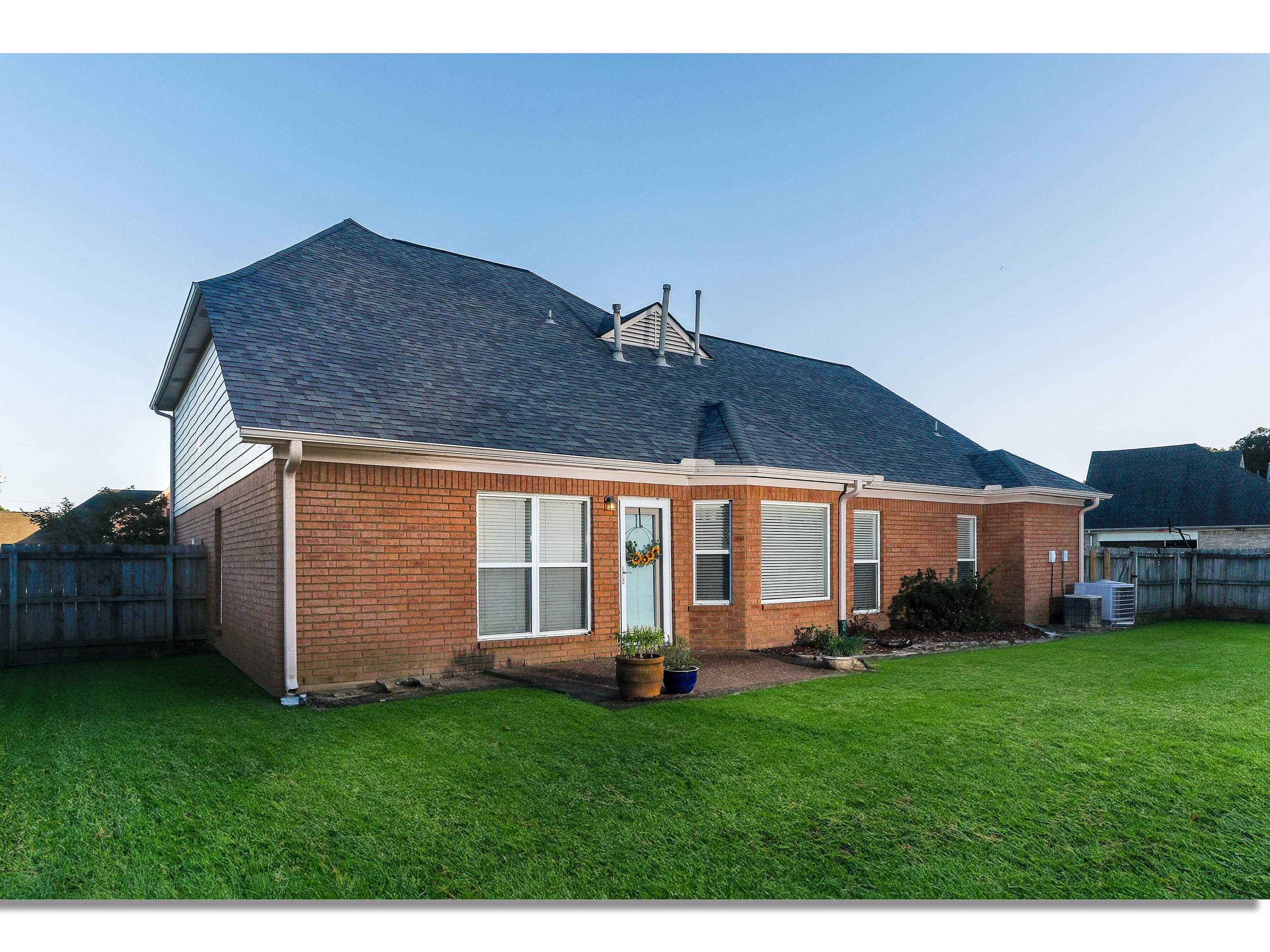 Back of house with a lawn