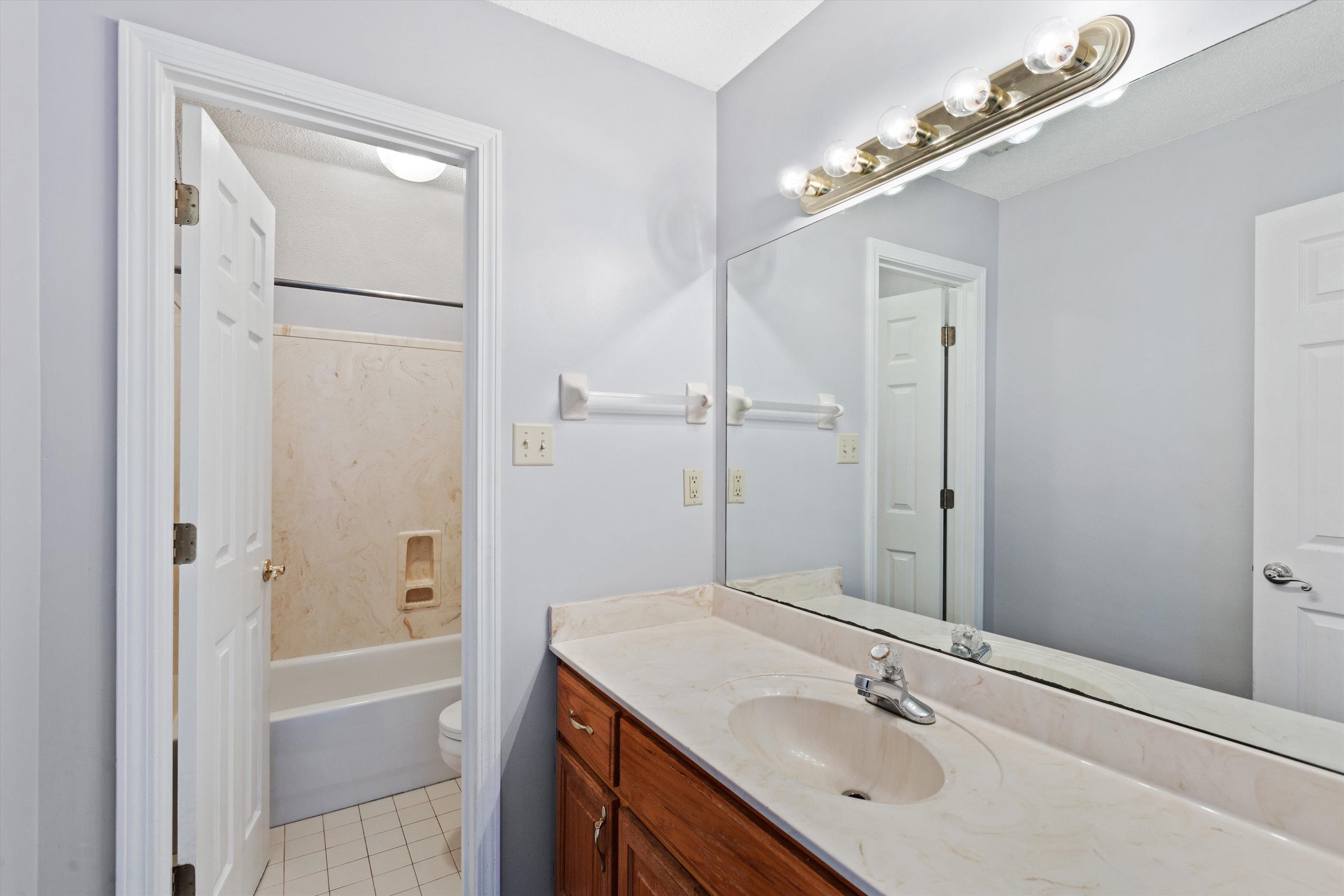 Full bathroom with tub / shower combination, vanity, and toilet