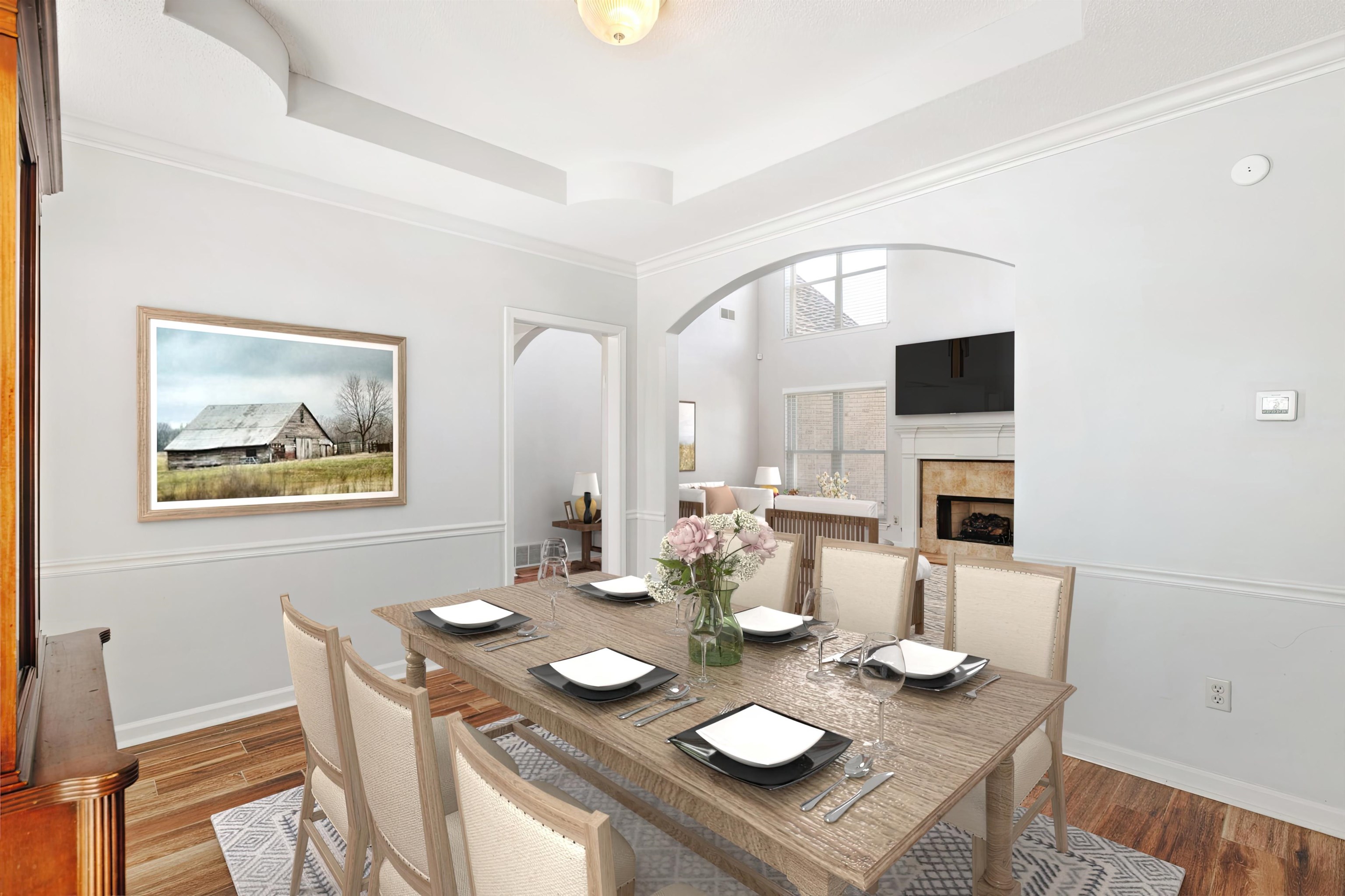 Dining room featuring light hardwood / wood-style flooring, a tray ceiling, a fireplace, and crown molding