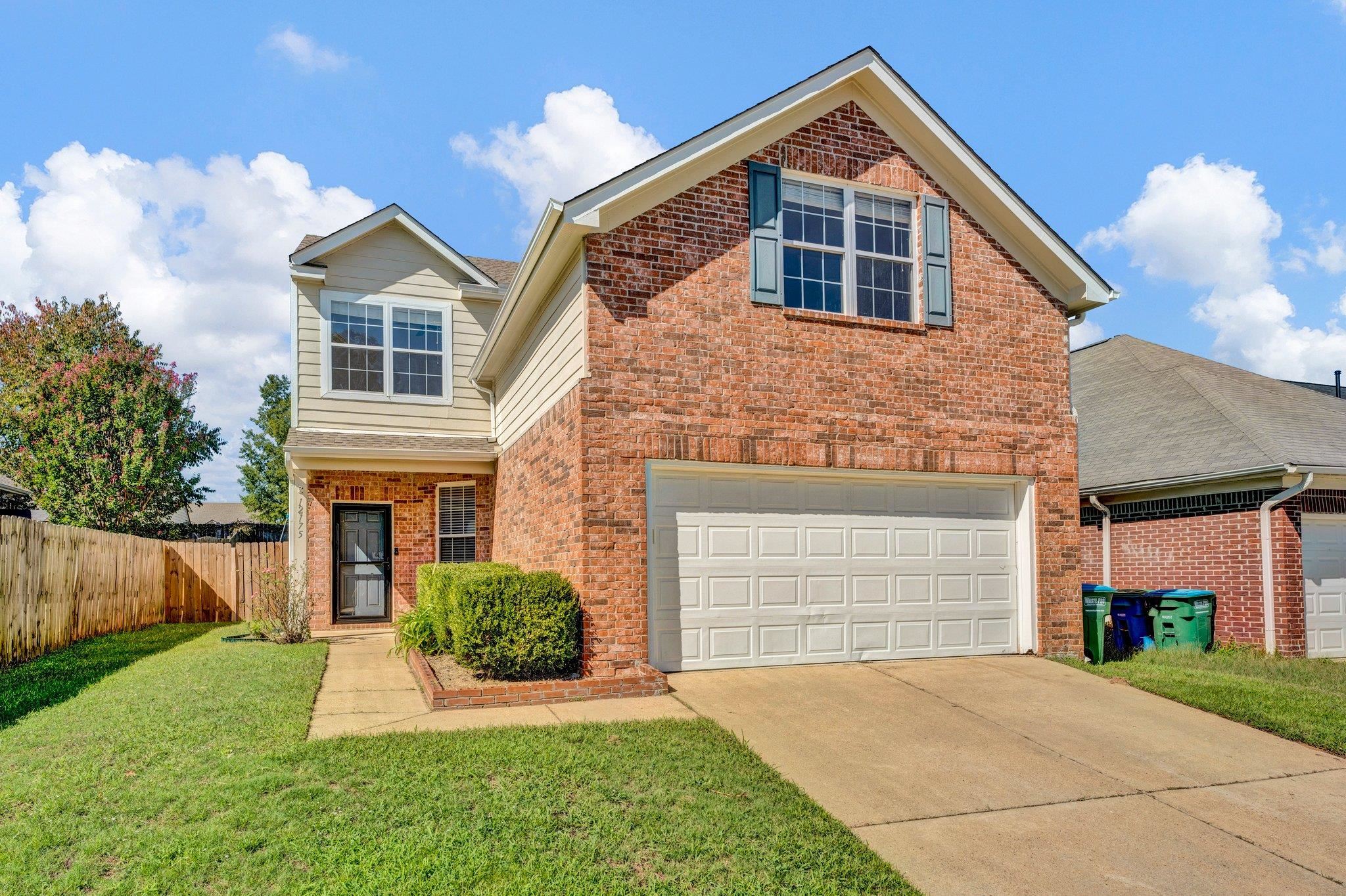 View of property featuring a front yard and a garage