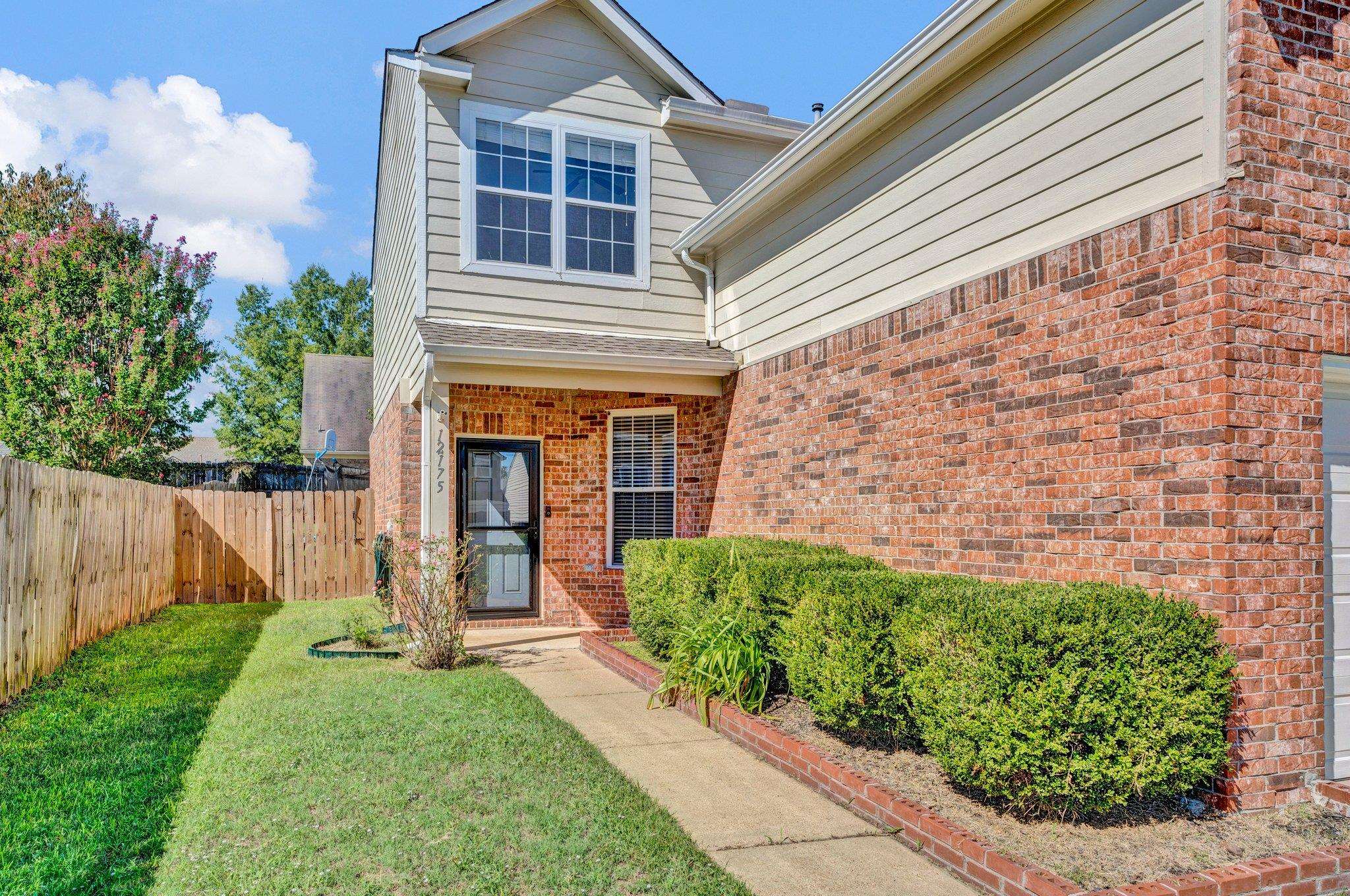 Doorway to property featuring a lawn