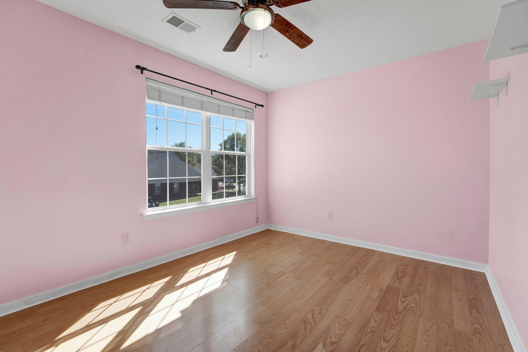 Unfurnished room featuring light wood-type flooring, ceiling fan, and a textured ceiling