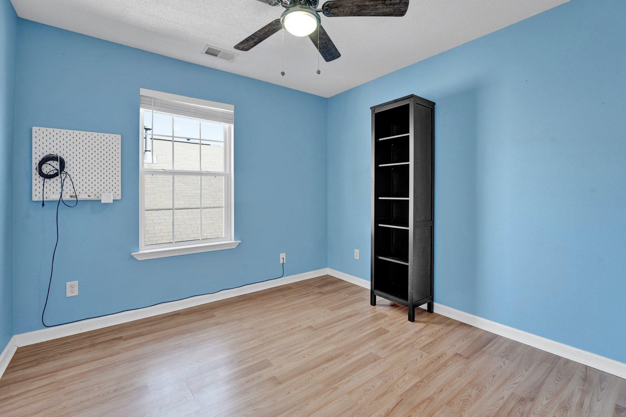 Empty room with a textured ceiling, ceiling fan, and light hardwood / wood-style flooring