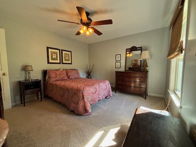 Bedroom with ceiling fan and light colored carpet