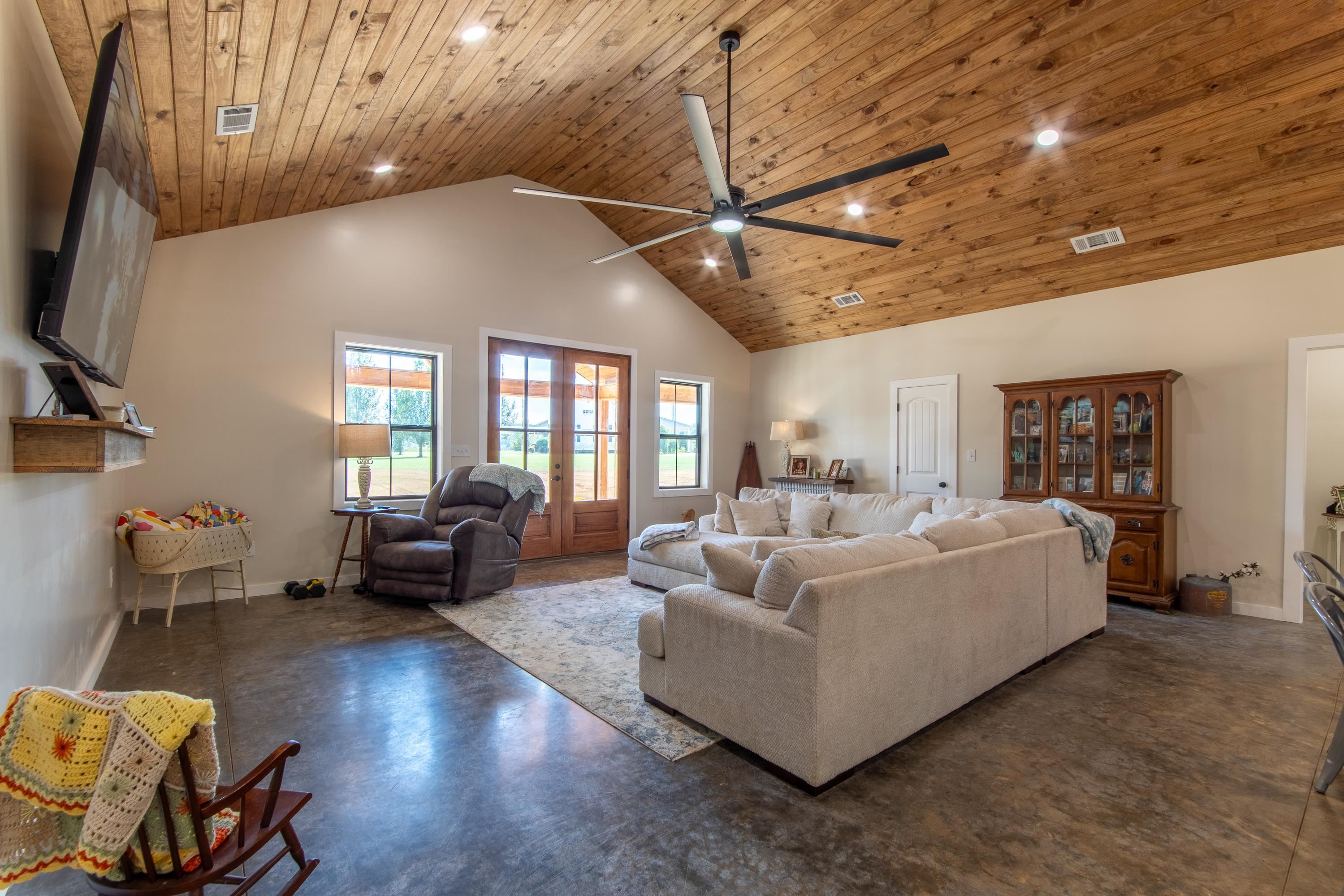 Living room featuring wooden ceiling, ceiling fan, french doors, and high vaulted ceiling