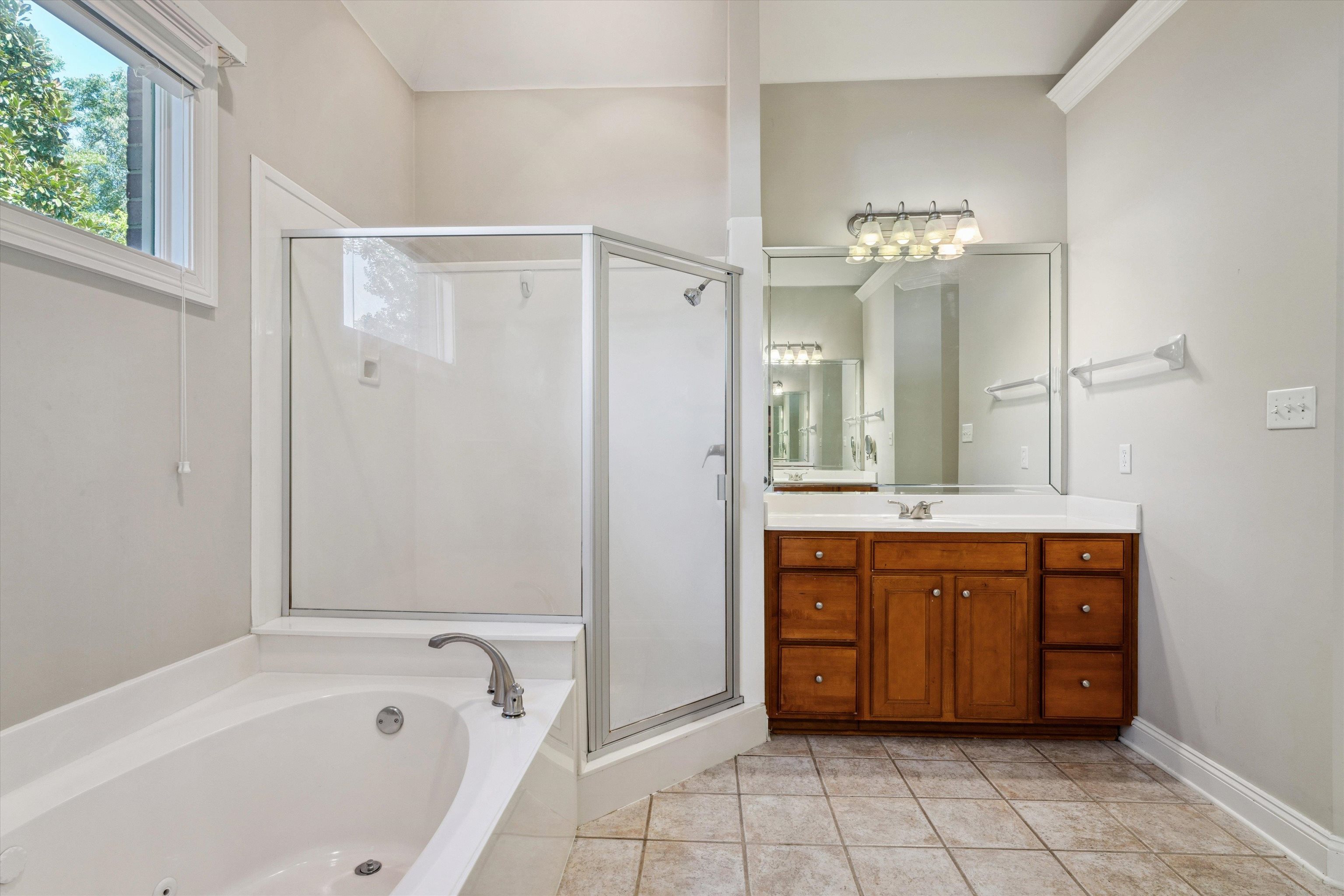 Bathroom featuring shower with separate bathtub, vanity, and tile patterned floors