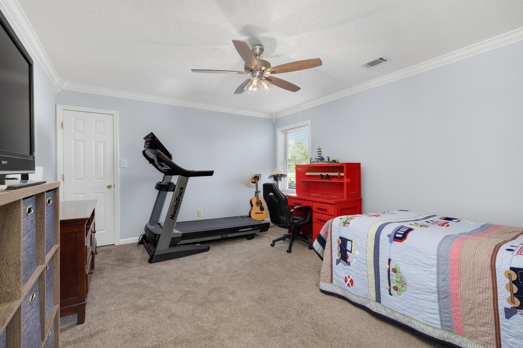 Newly carpeted bedroom featuring a textured ceiling, ceiling fan, and crown molding