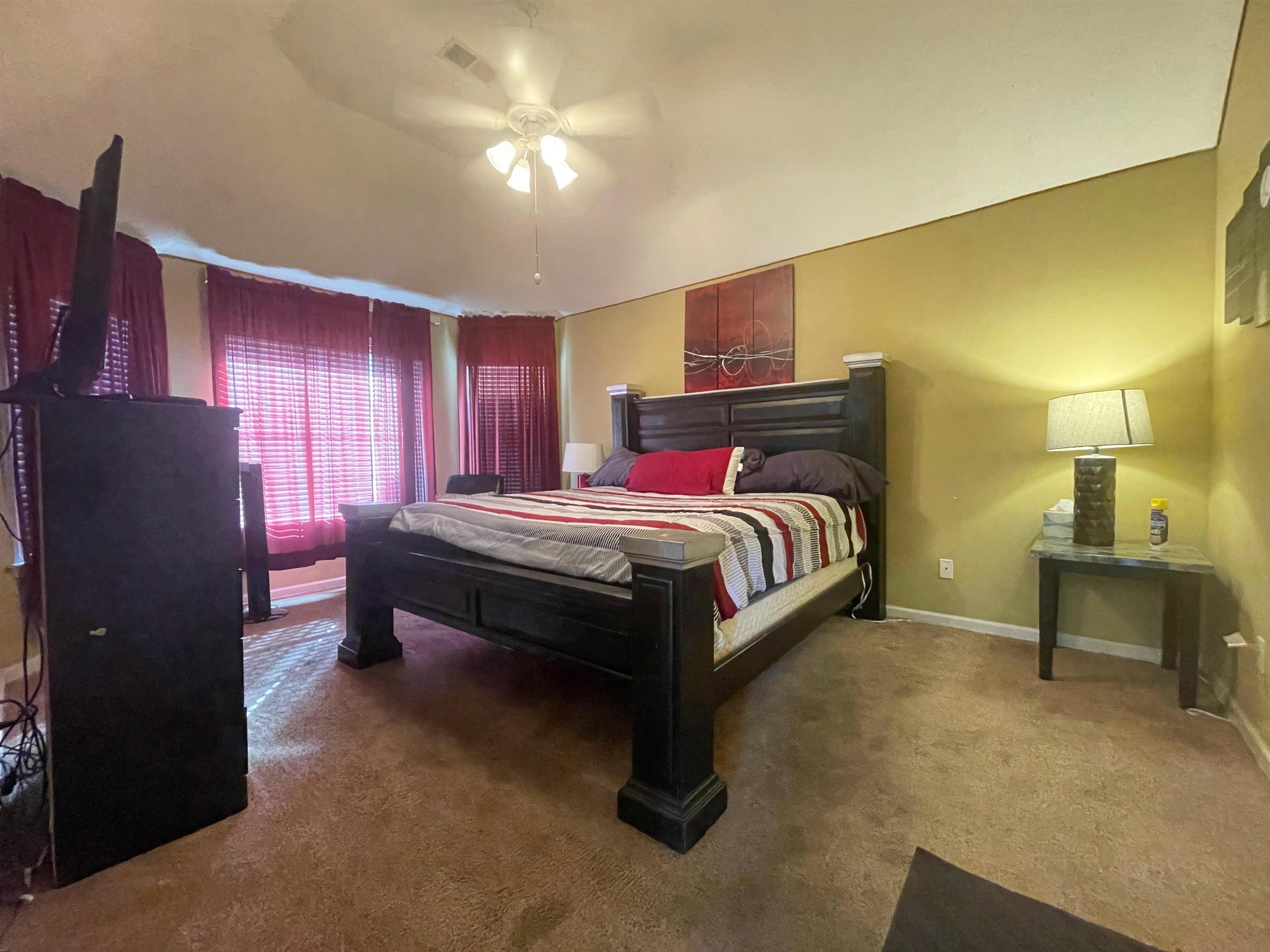 Bedroom with dark carpet and ceiling fan