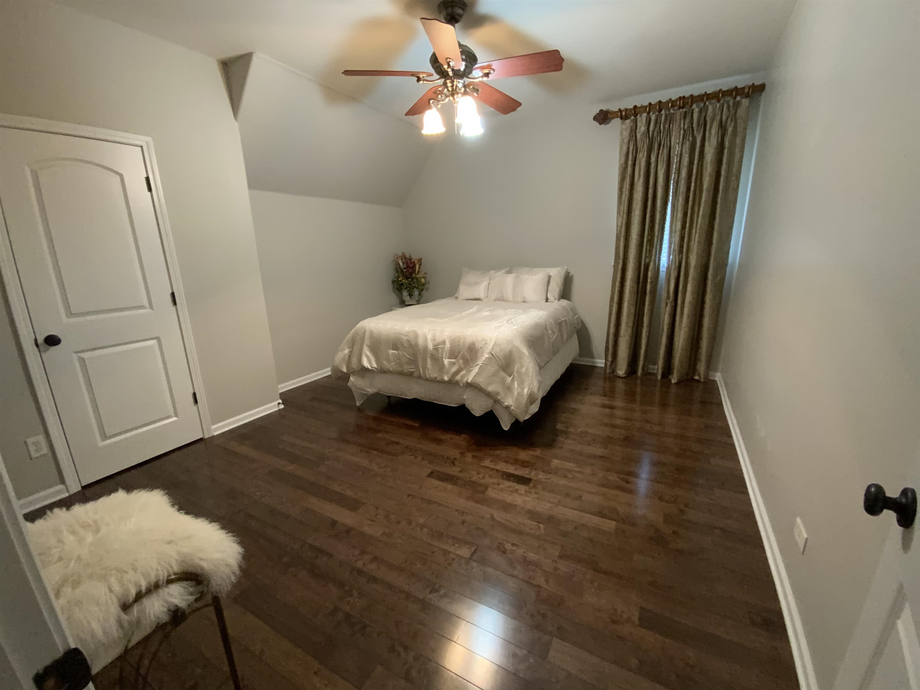 Bedroom featuring ceiling fan, lofted ceiling, and dark hardwood / wood-style floors