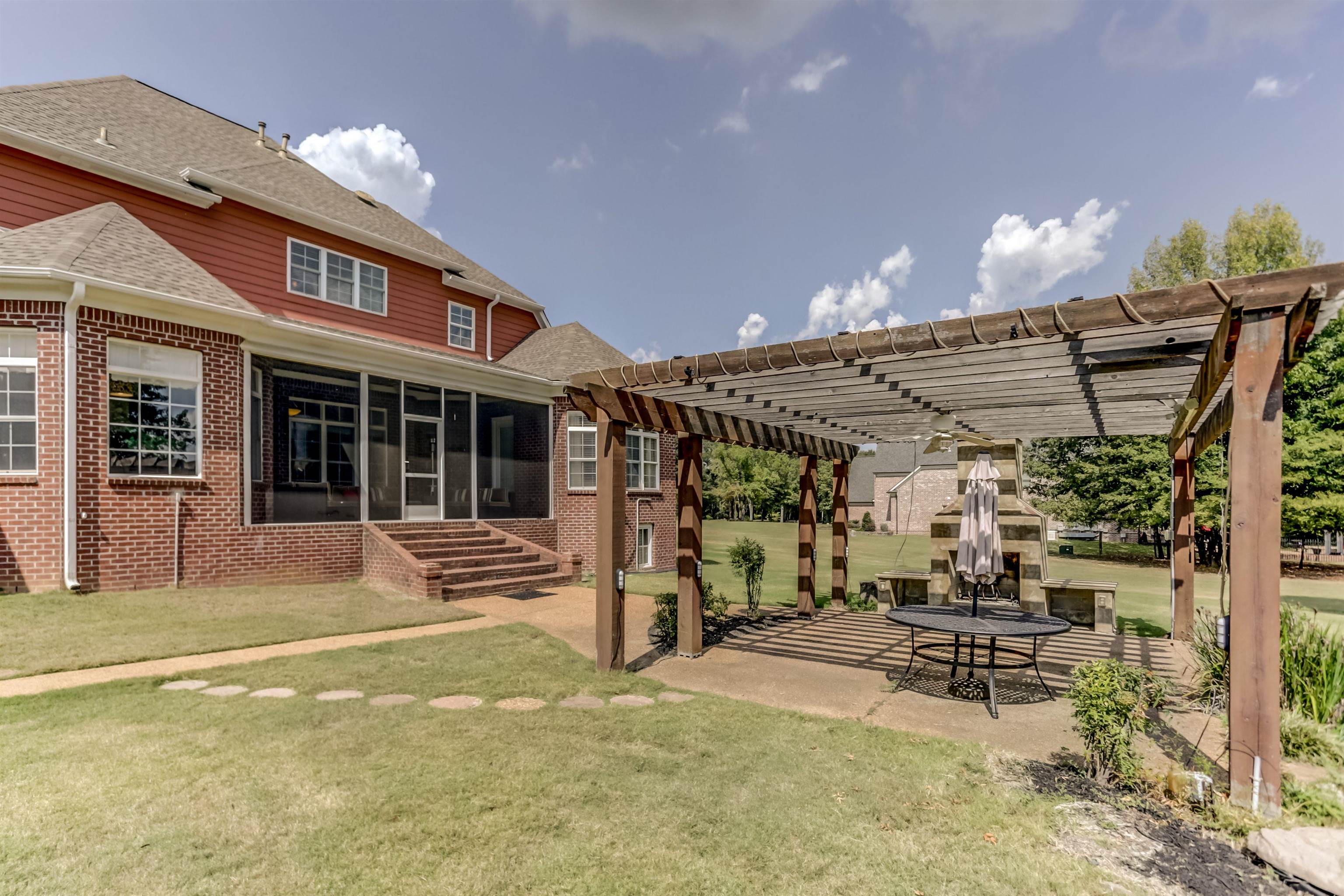 Exterior space featuring a yard, a sunroom, a pergola, and a patio