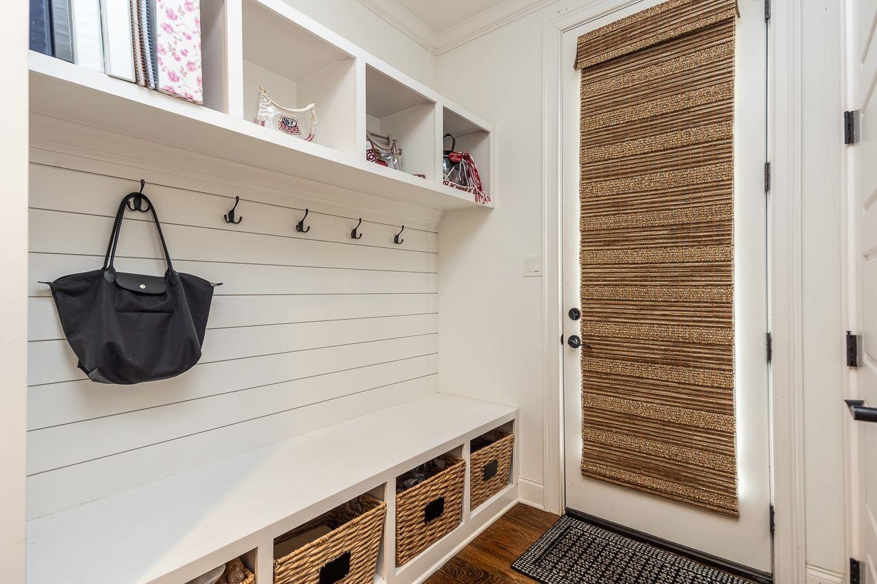 Mudroom with dark hardwood / wood-style floors and crown molding