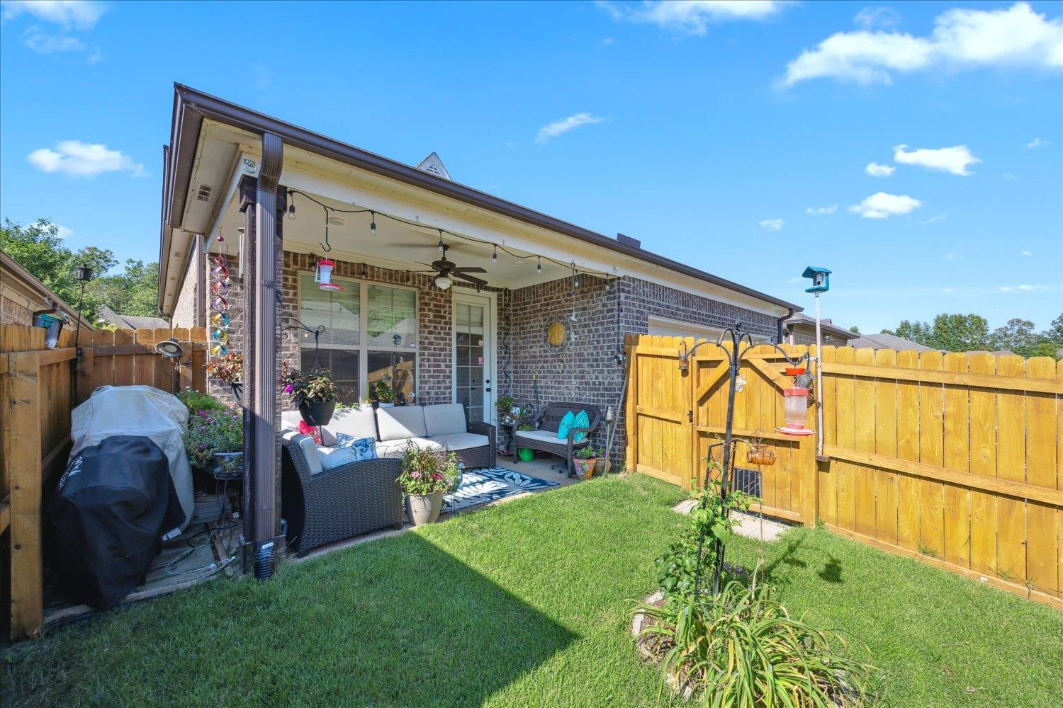 Rear view of house featuring a lawn, an outdoor living space, ceiling fan, and a patio area