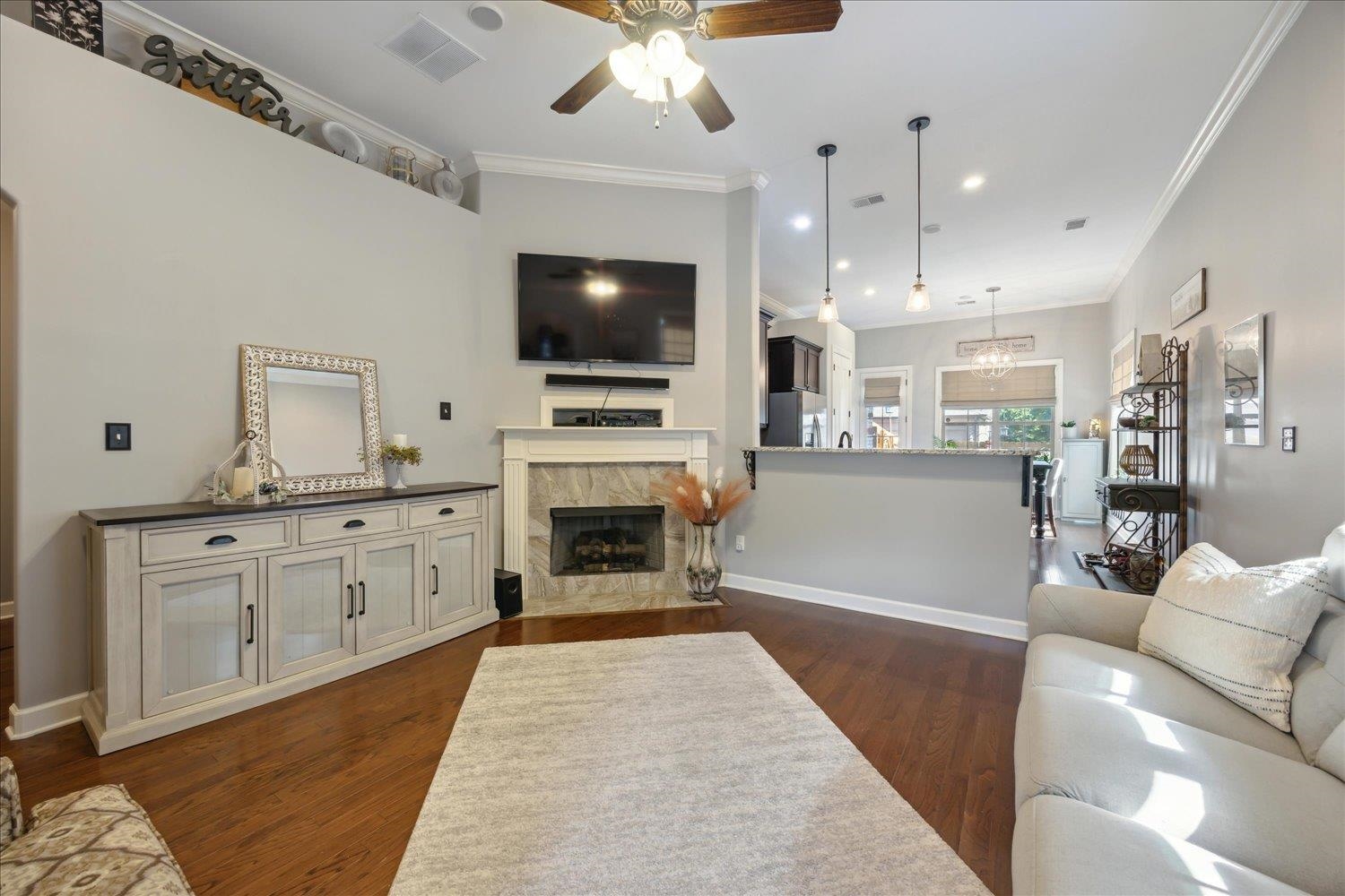 Living room featuring ornamental molding, dark hardwood / wood-style flooring, and a high end fireplace