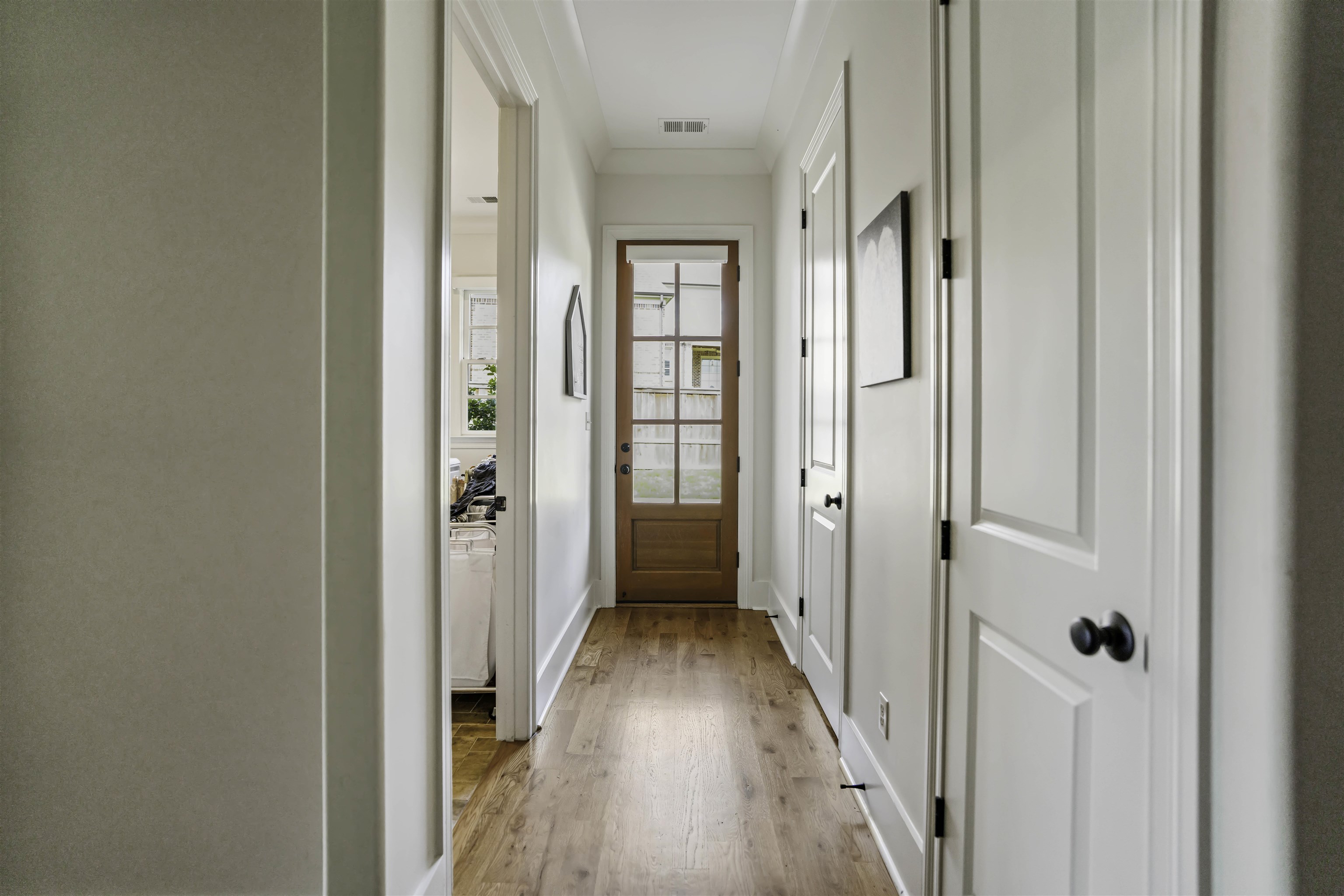 Doorway to outside with light wood-type flooring and ornamental molding