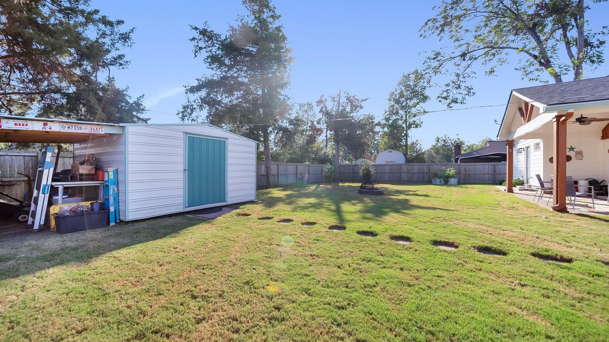 View of yard with a patio and a storage shed