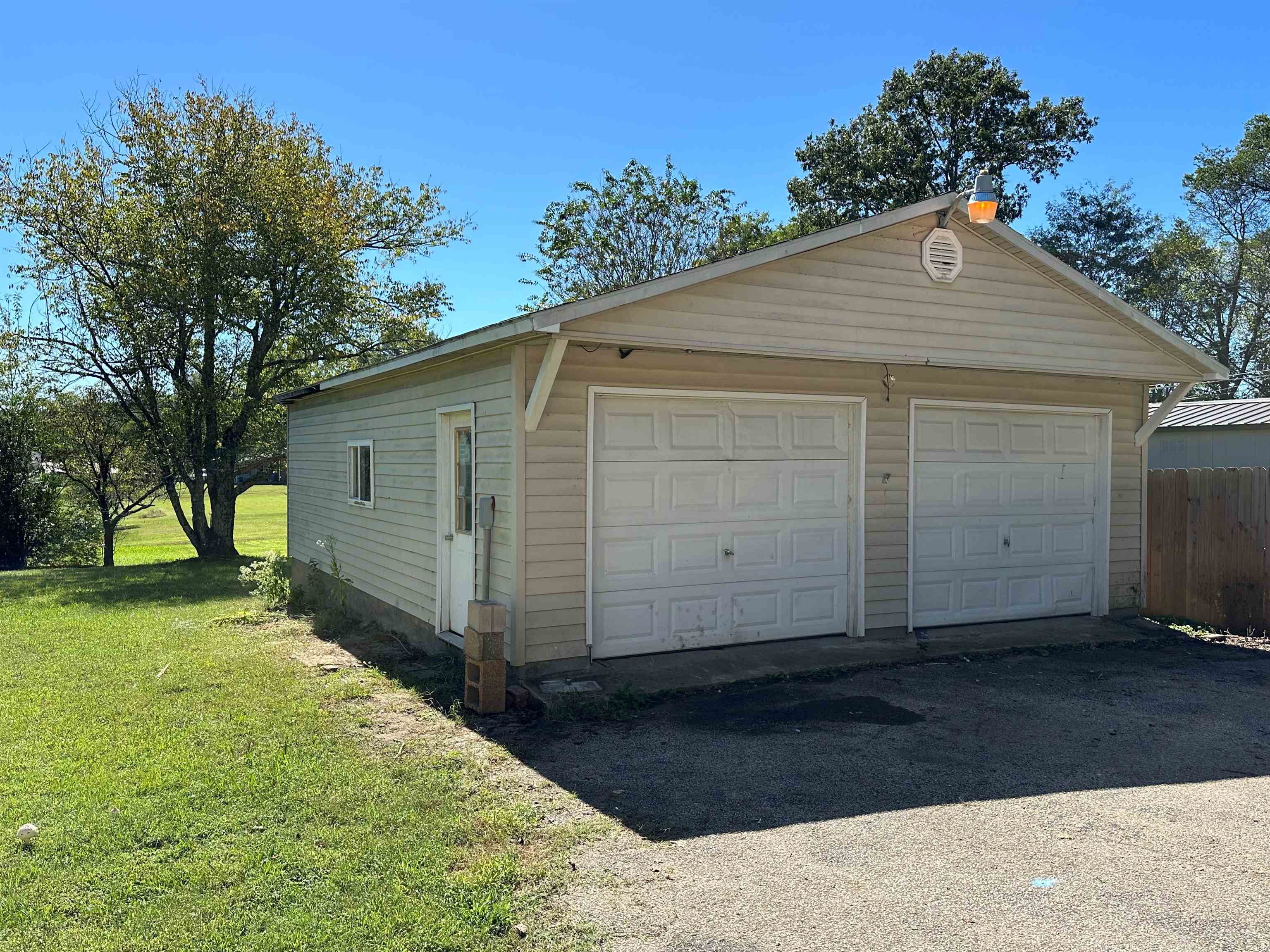 Garage featuring a lawn and wood walls