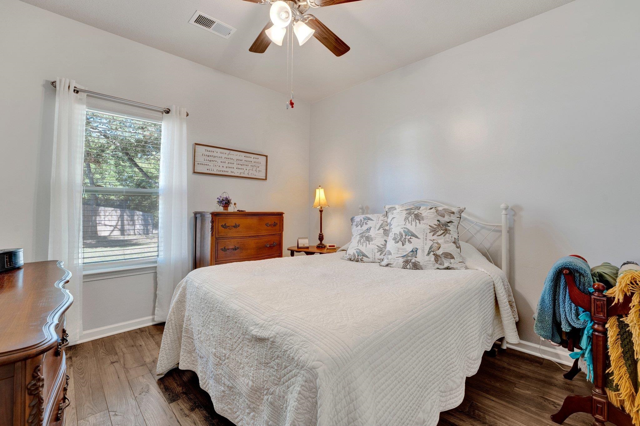 Bedroom with ceiling fan and dark hardwood / wood-style flooring