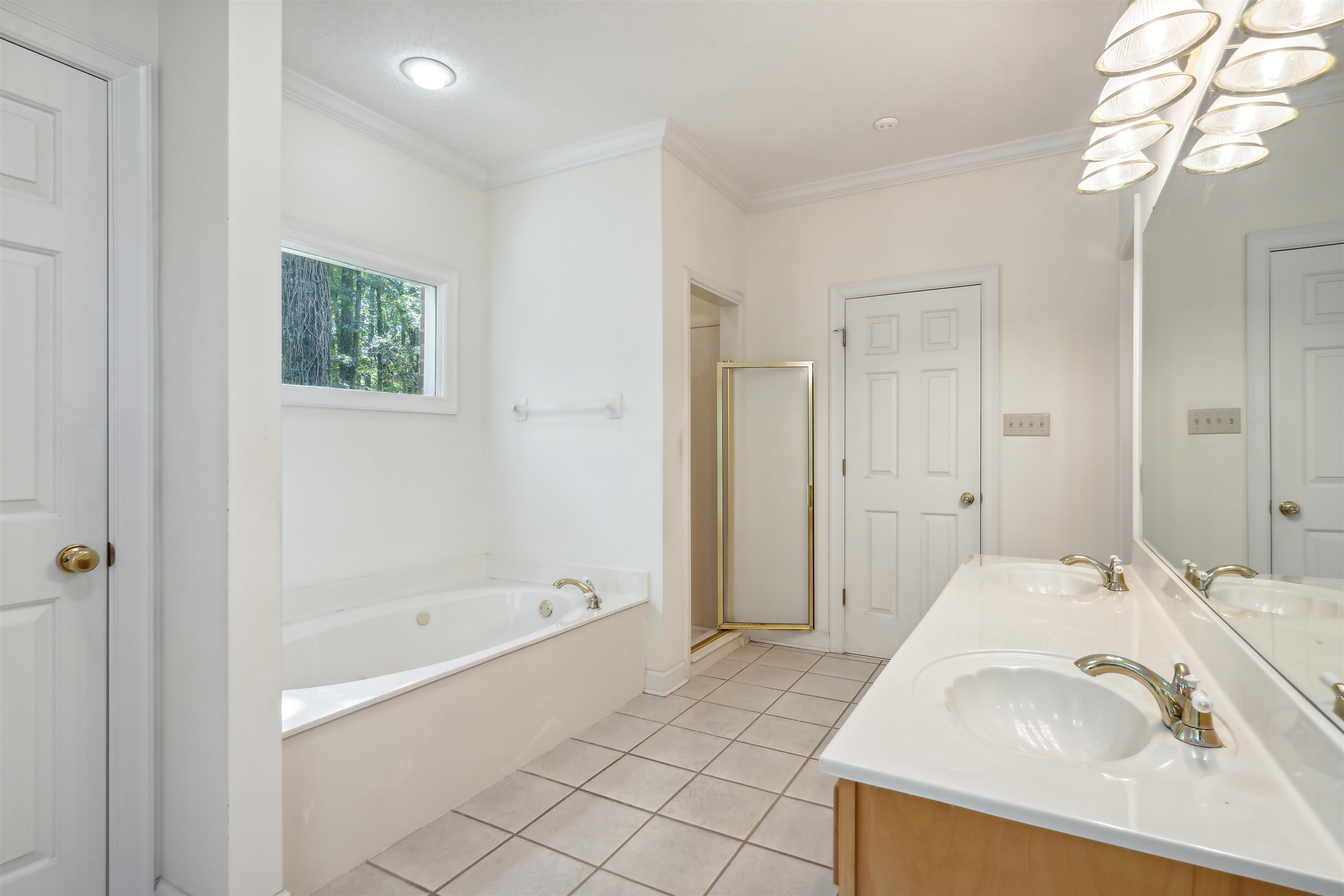Bathroom with vanity, separate shower and tub, crown molding, and tile patterned floors